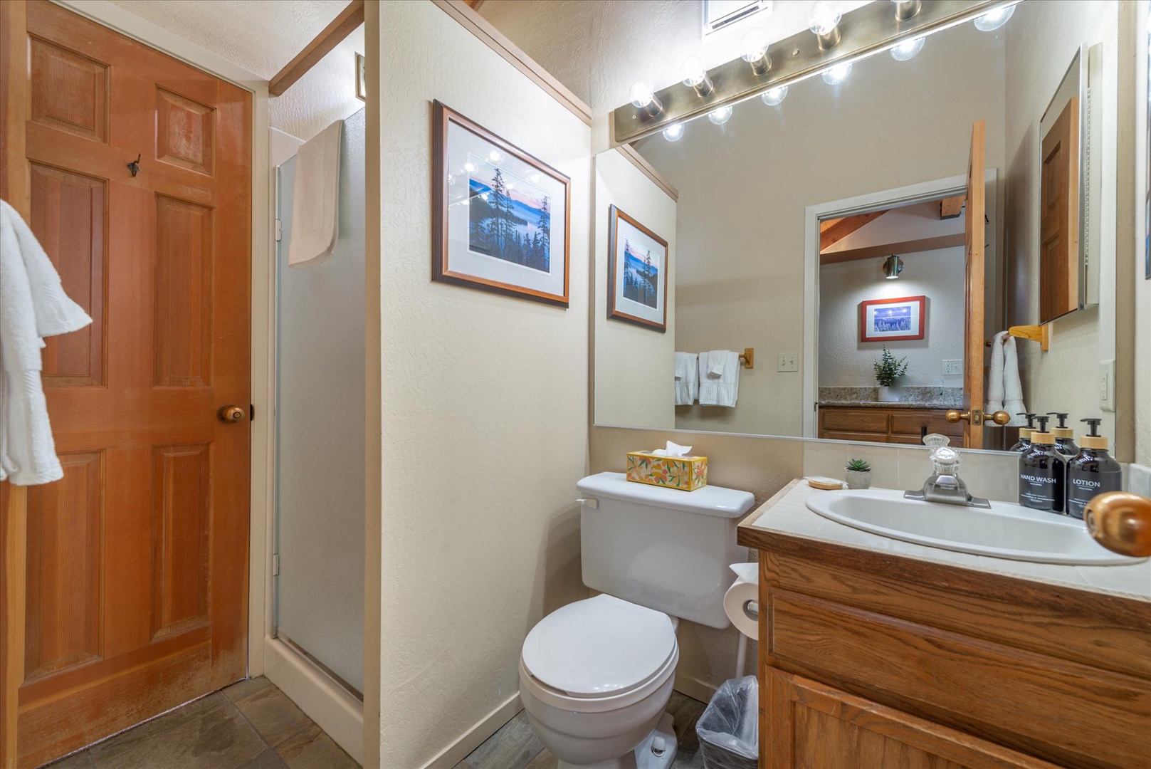 Freshen up in your private bathroom with classic wood cabinetry, bright vanity lighting, and all the essentials you need for a comfortable mountain getaway.
