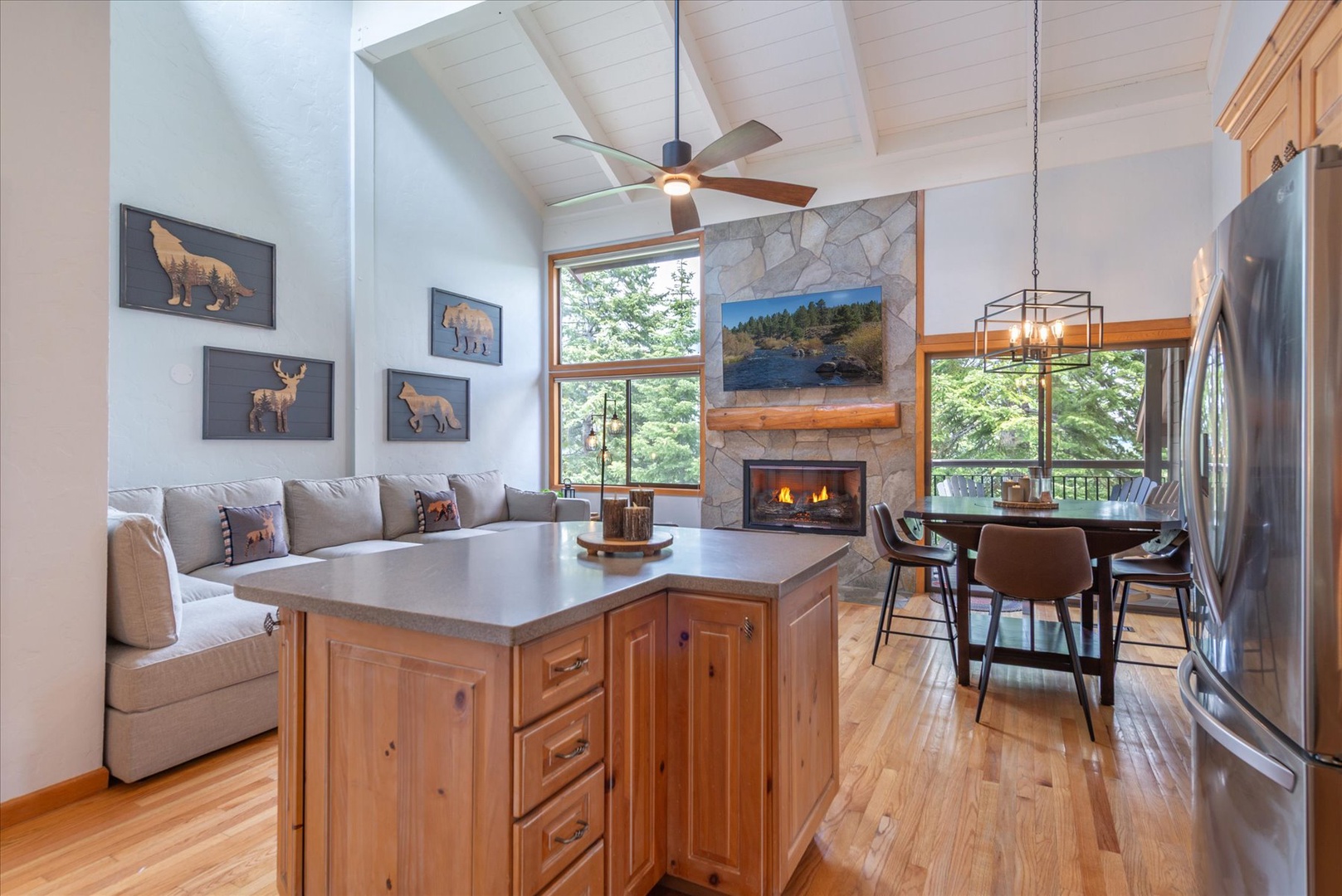 Vaulted ceilings and sunlight stream through expansive windows to create an inviting open-concept living space where the whole group can feel connected.