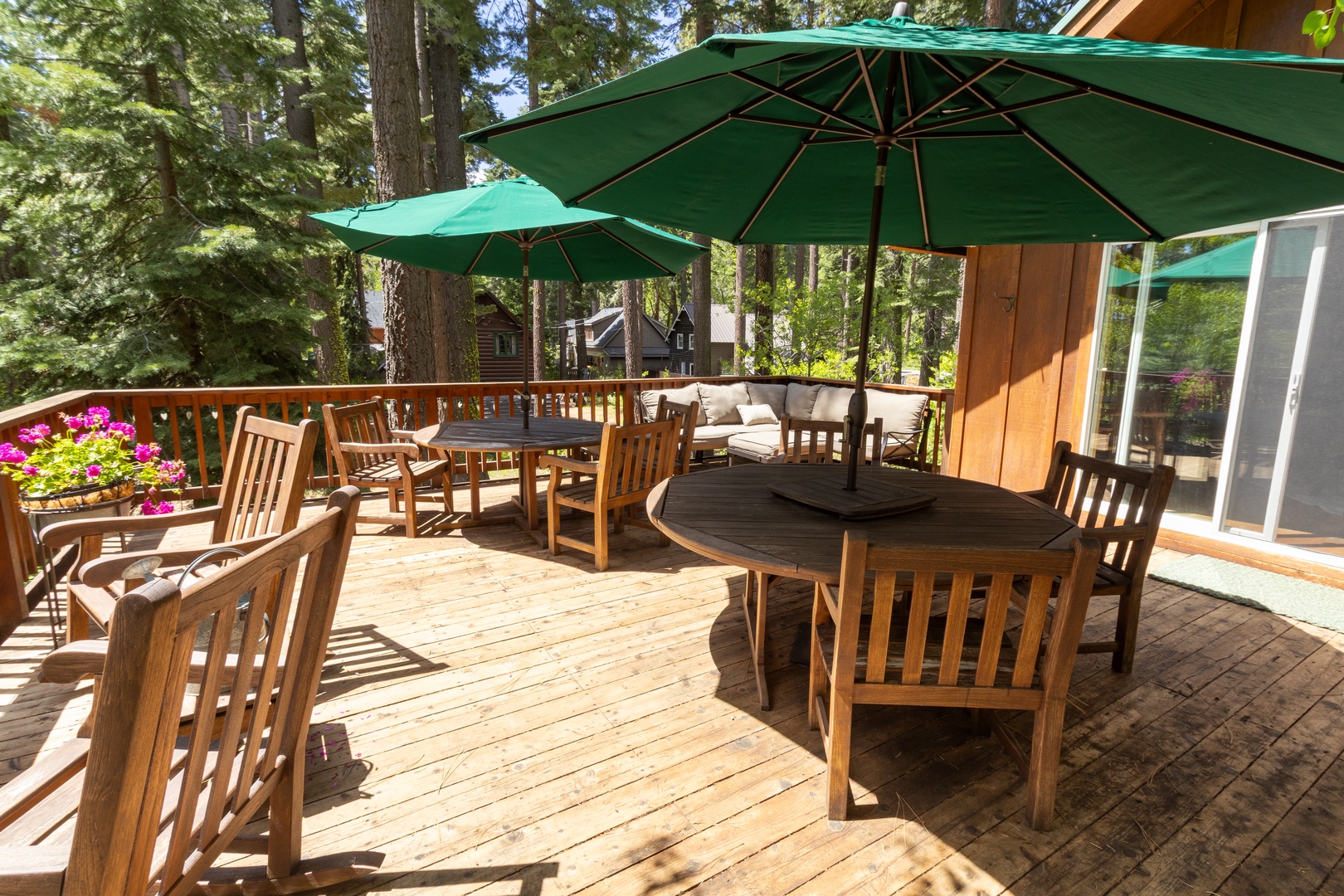 Step onto your private deck surrounded by towering pines, where sunny outdoor dining awaits under cheerful umbrellas. Perfect for morning coffee or evening gatherings in nature's embrace.