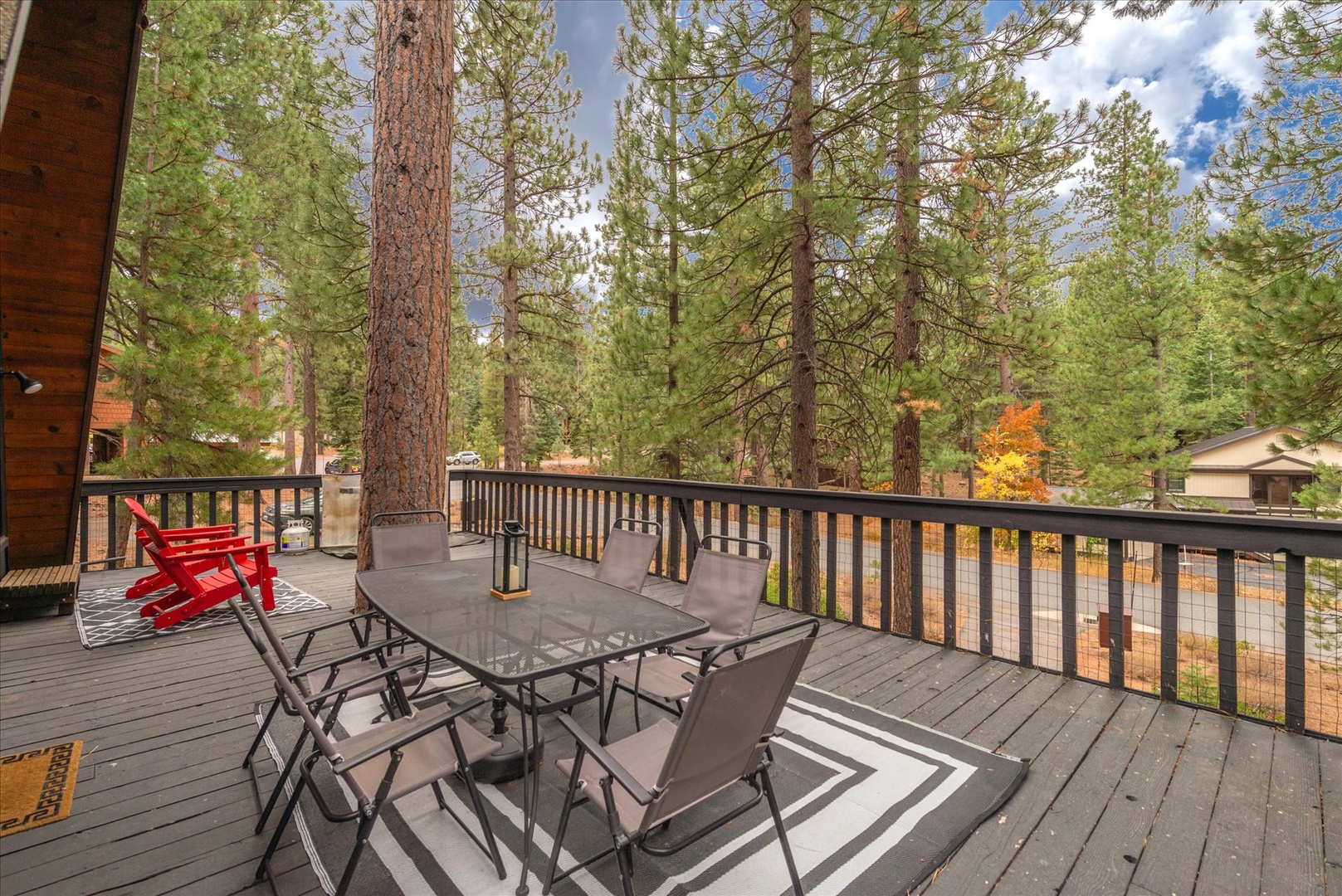 This large deck is nestled among towering pines, where your morning coffee meets birdsong and crisp mountain air. The dining setup invites you to savor meals outdoors, surrounded by peaceful forest views and seasonal color.