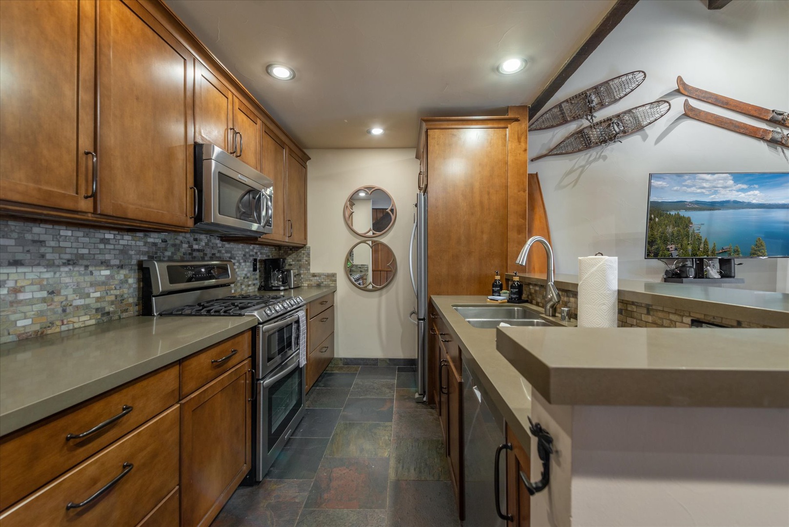 Cook memorable meals in your fully-equipped kitchen with warm wood cabinetry, modern appliances, and elegant tile backsplash.