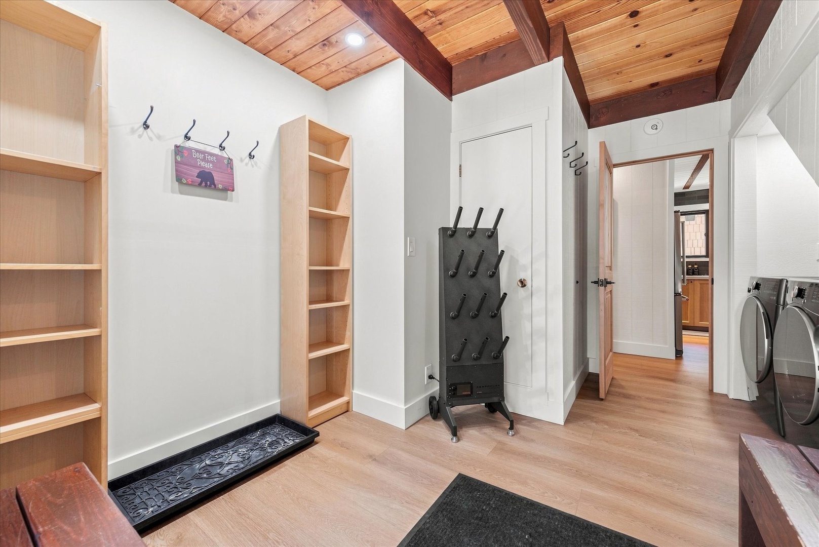 Your thoughtfully designed mudroom entryway where all your gear has a place with hooks, shelving, and a convenient washer and dryer tucked nearby.