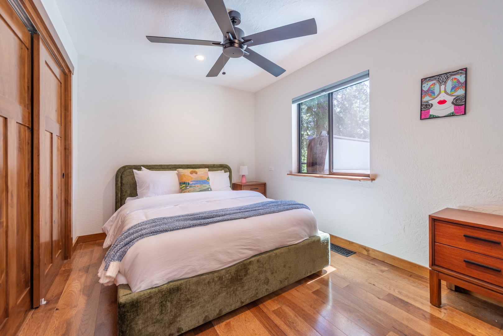 Step into your serene retreat, in the third queen bedroom located downstairs, where soft linens invite you to unwind after a day of exploring. Natural light streams through the window while a gentle ceiling fan keeps you comfortable year-round.