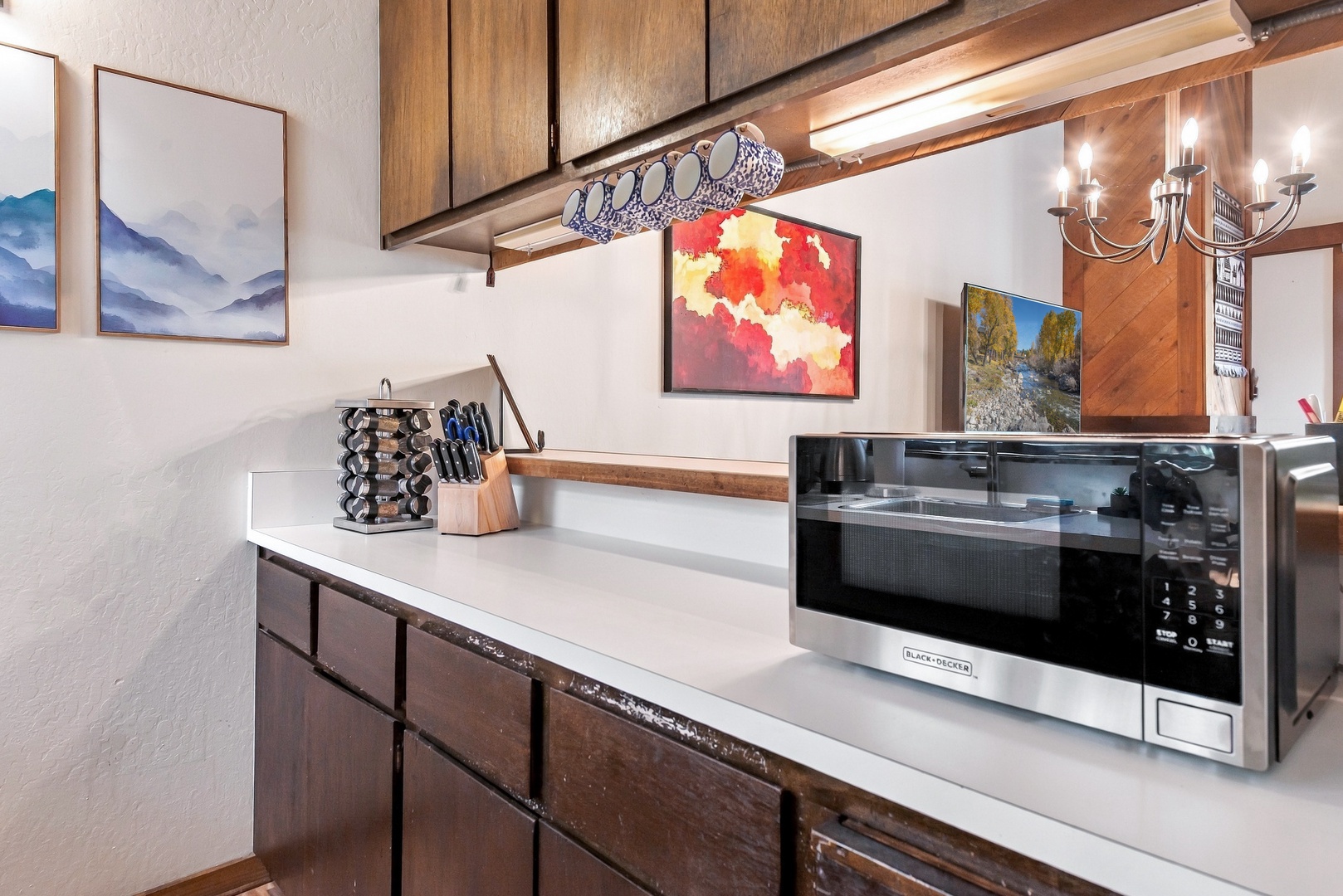 Prepare your favorite meals in this well-appointed kitchen featuring warm wood cabinetry, modern appliances, and a spacious countertop—ideal for cozy mountain getaway cooking.