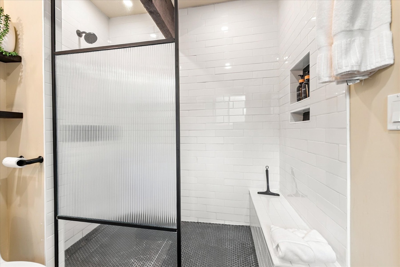 Step into your private spa-like retreat. Crisp white tile, sleek black fixtures, and a spacious walk-in shower invite you to unwind after a day of exploring.