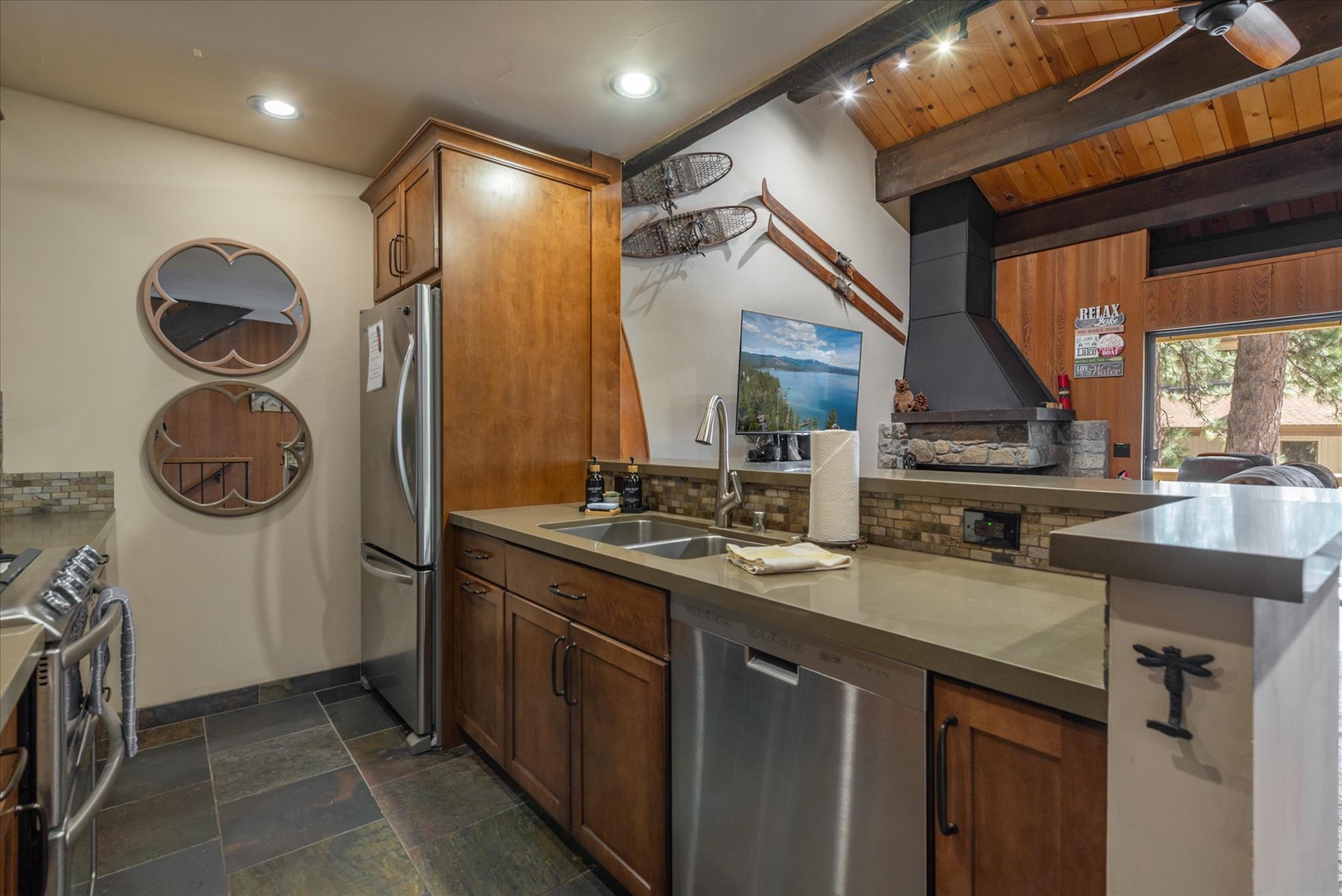Your mountain retreat kitchen blends rustic charm with modern convenience—exposed beams, warm wood cabinets, and stainless appliances create the perfect space for memorable meals.