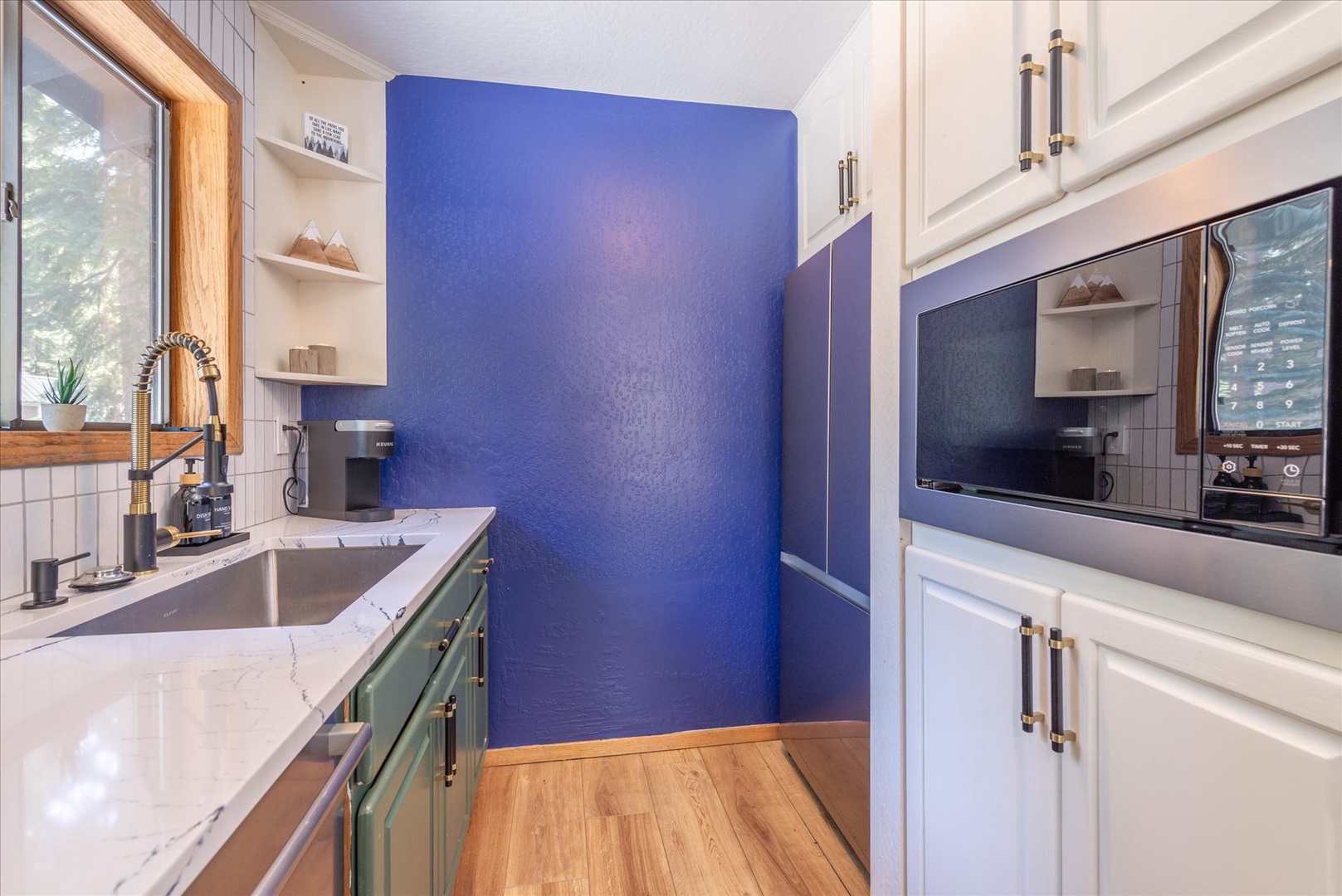 You'll love cooking in this stylish kitchen featuring bright blue accents and modern appliances for your culinary adventures.