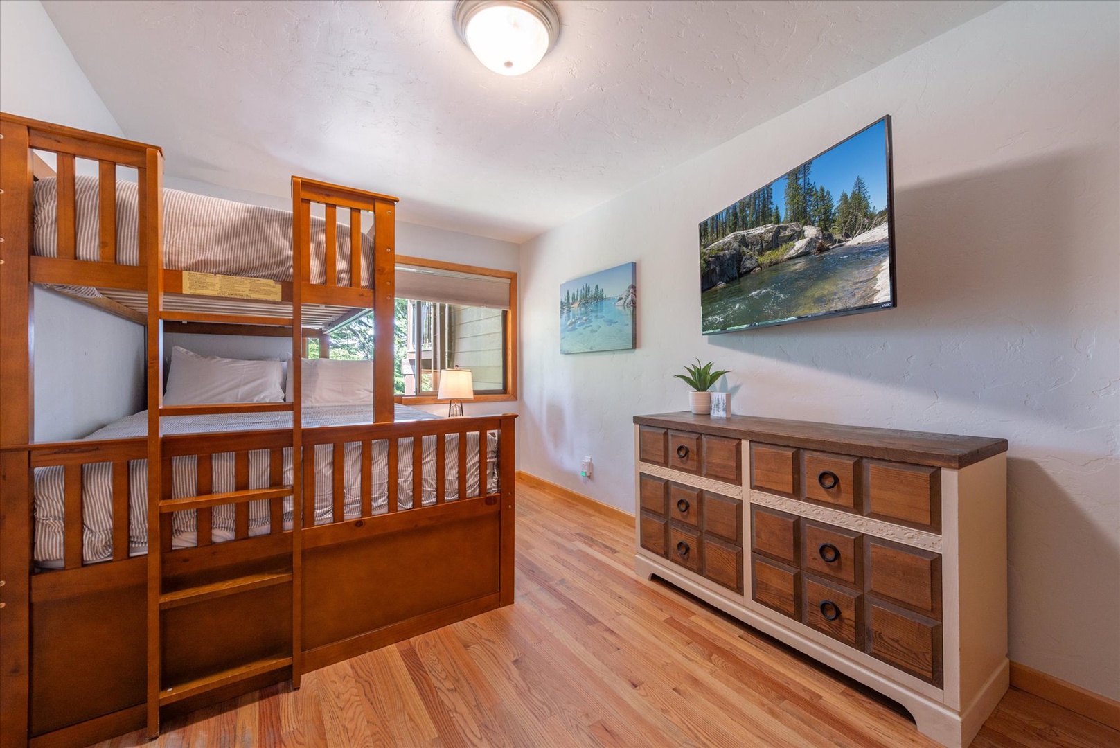 Families will love this cozy bunk room with its warm wood tones and its own TV.