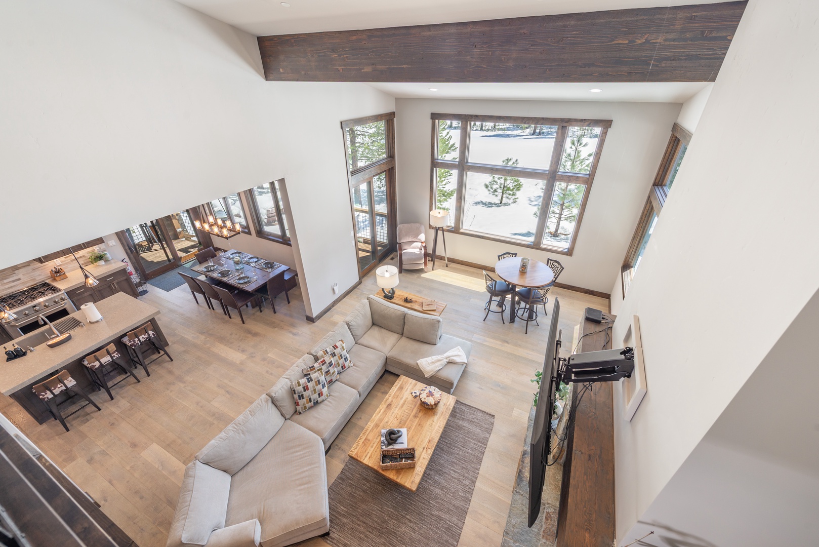 Step into your spacious open-plan living area where modern comfort meets rustic charm. Relax on plush seating while enjoying natural light streaming through large windows.