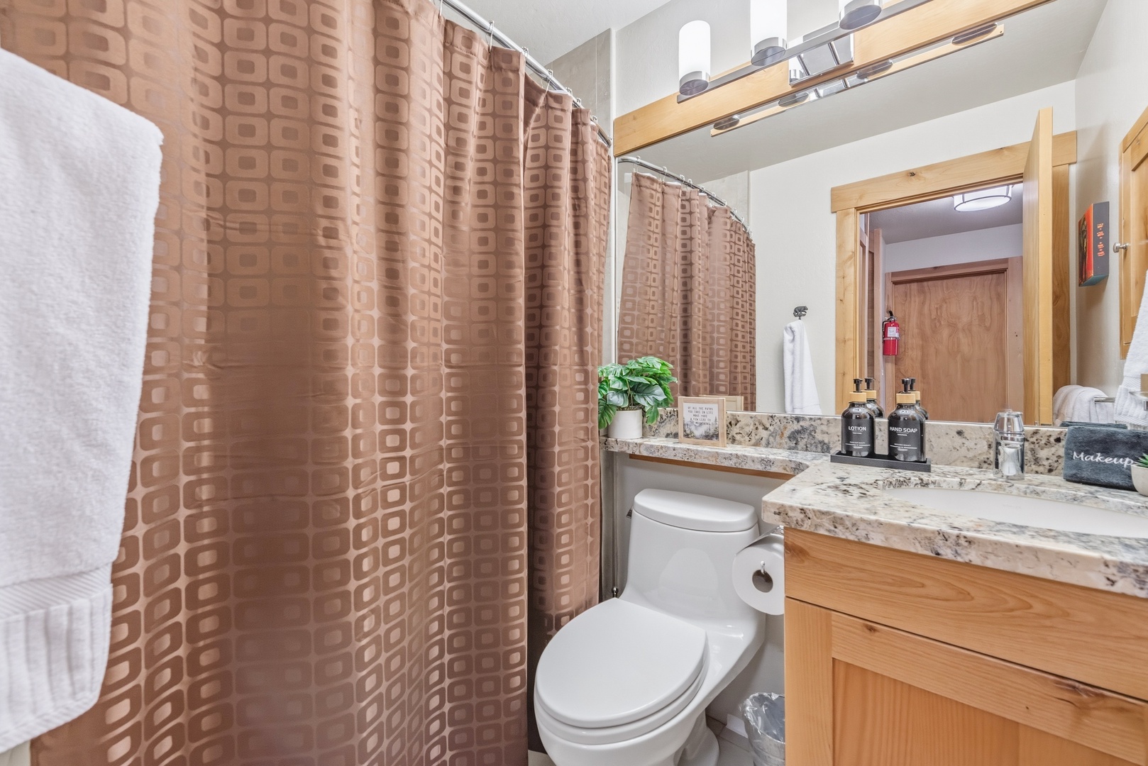 Refresh in your private bathroom featuring a spacious shower, granite vanity, and warm wood accents that create a welcoming retreat after your day's adventures.
