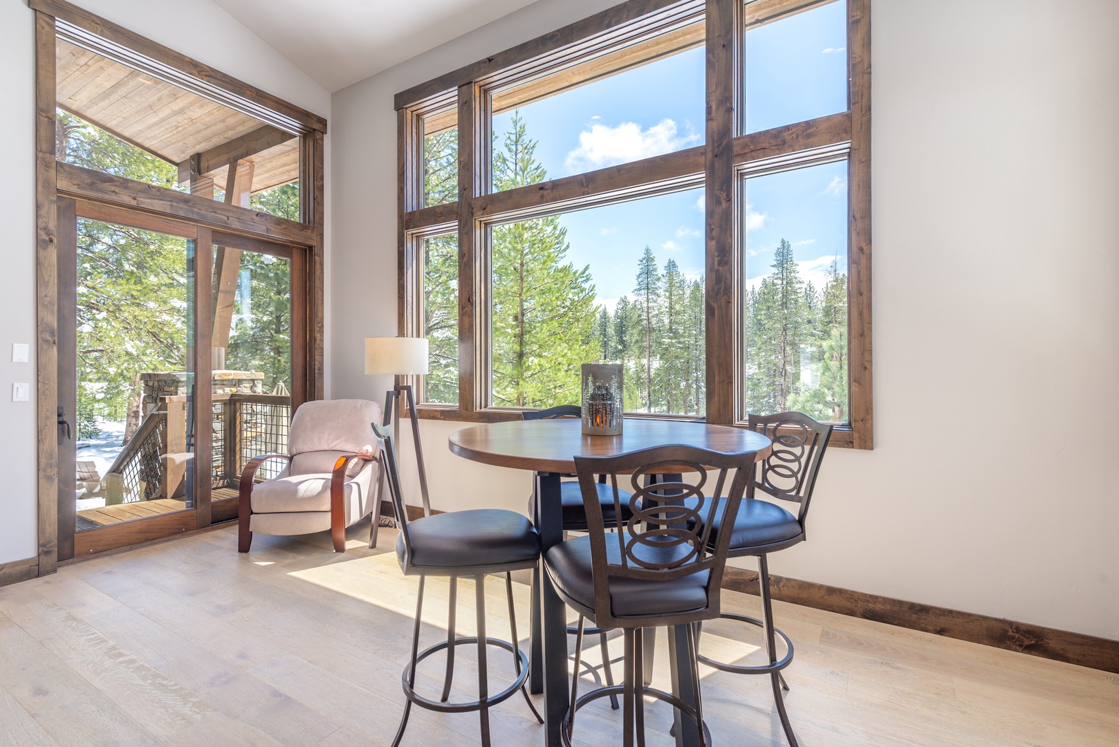 Enjoy morning coffee at your intimate dining table while soaking in stunning forest views through floor-to-ceiling windows.
