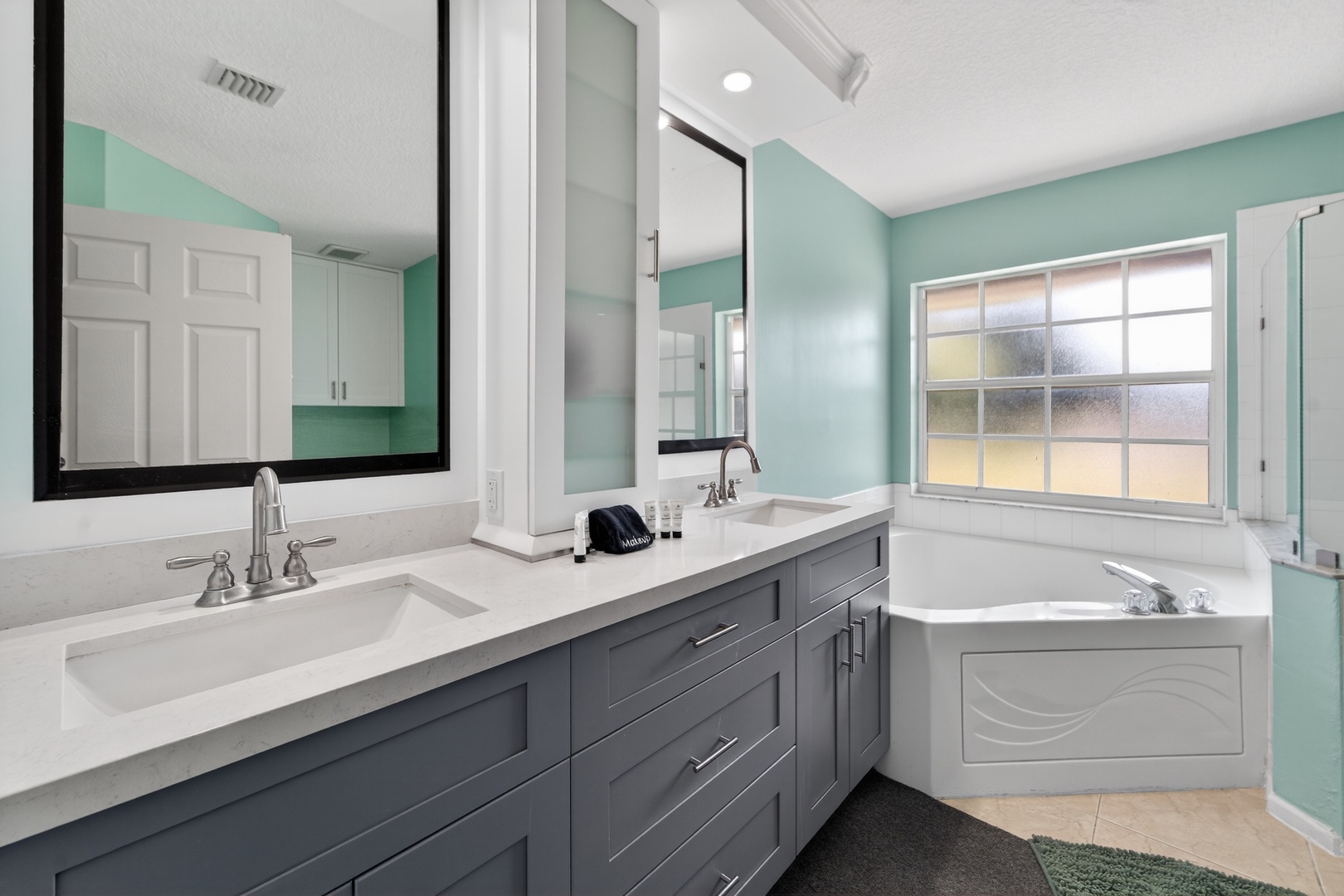 Unwind in your spa-like bathroom with dual vanities, soaking tub, and calming seafoam walls that create the perfect retreat.