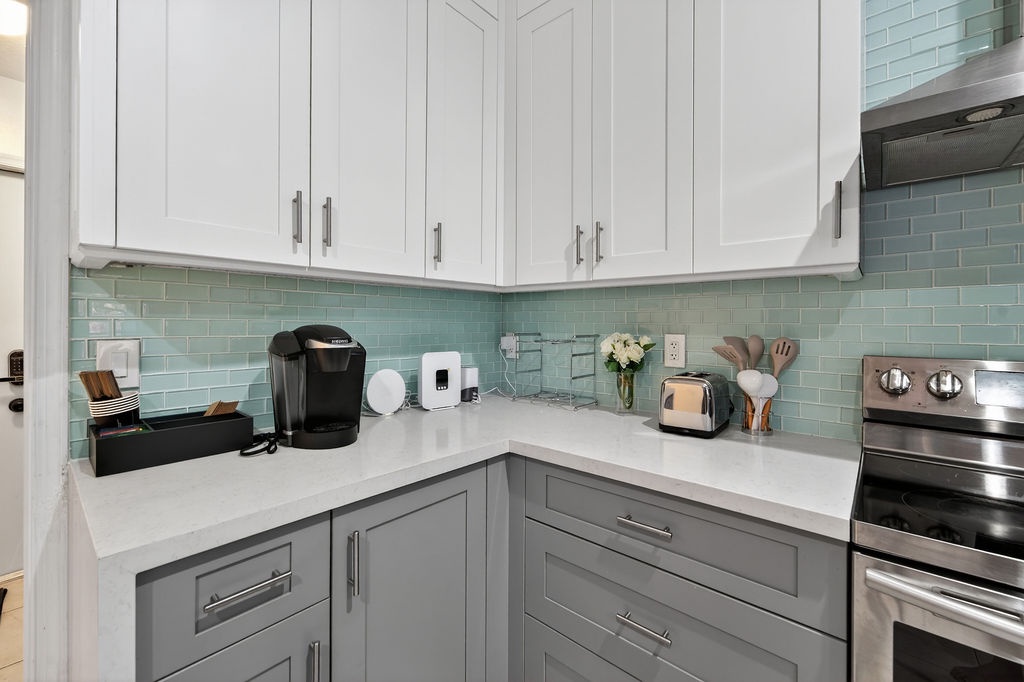 Your fully equipped kitchen awaits with elegant cabinetry, modern appliances, and soothing mint subway tile—perfect for brewing morning coffee or preparing meals.