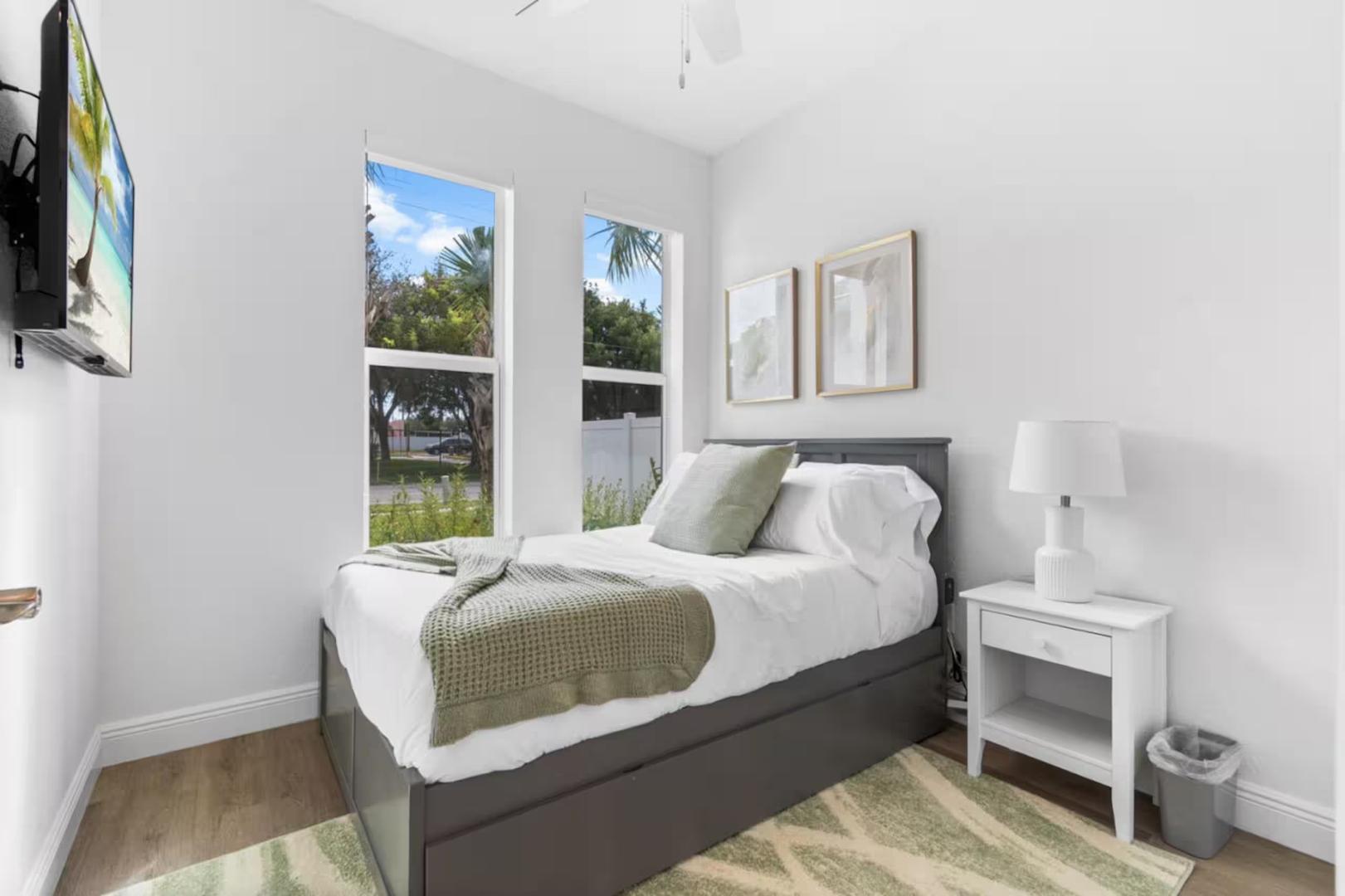 Sink into crisp linens and wake to natural light streaming through large windows that frame peaceful neighborhood views. Your bright, serene retreat awaits with modern comforts and calming coastal tones.
