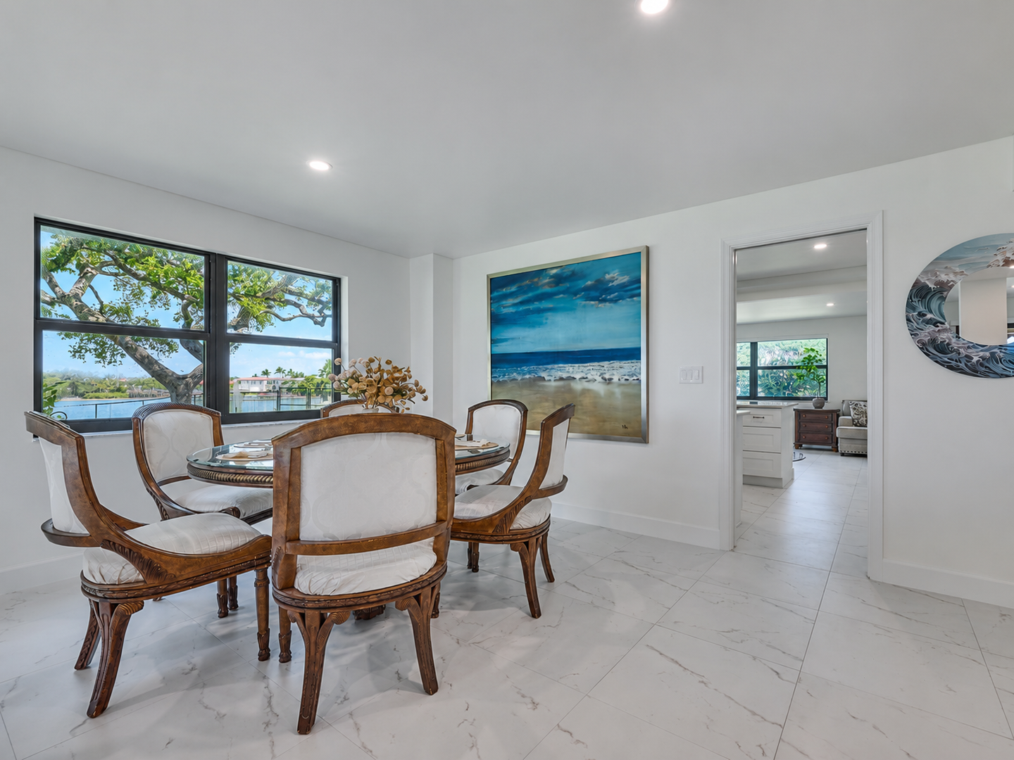 Gather around the table in this bright, airy dining space where natural light pours in through large windows, offering you a relaxing spot to share meals and conversations.