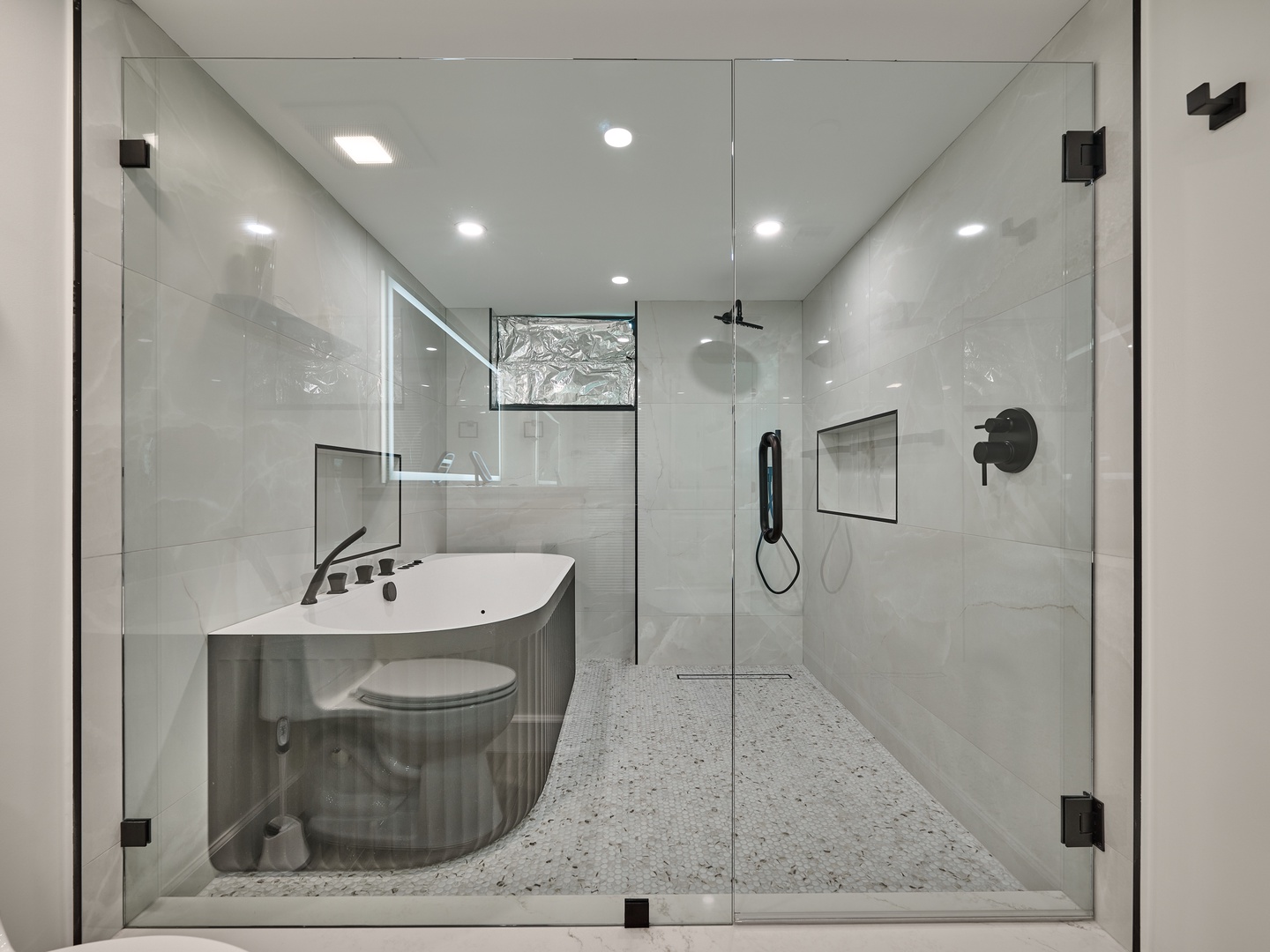 Step into your private spa-like sanctuary, where a sleek glass-enclosed rainfall shower and a luxurious soaking tub invite you to unwind in modern elegance.
