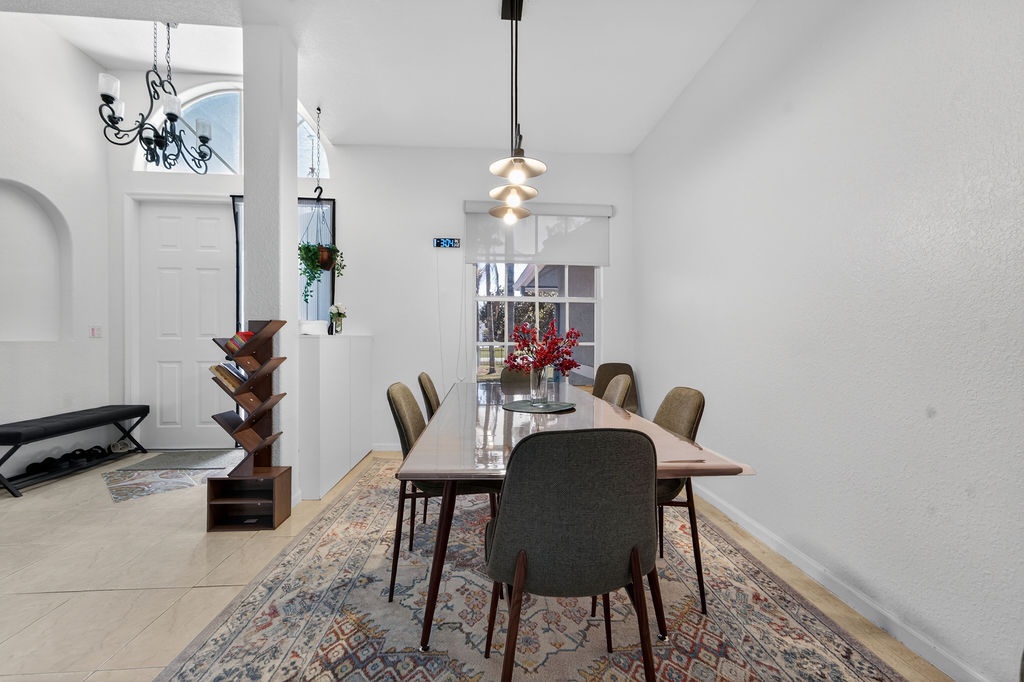 Gather around your elegant dining table where warm pendant lighting creates the perfect ambiance for memorable meals together.