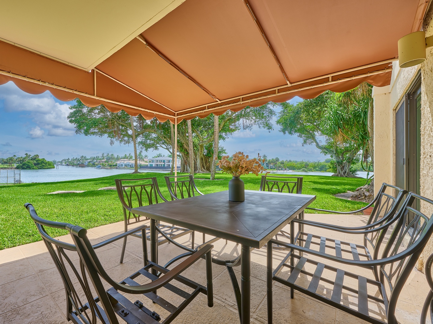 A waterfront oasis awaits. Step onto your covered patio where meals are shared, breezes drift across the lawn, and tranquil lake views frame every moment of your stay.