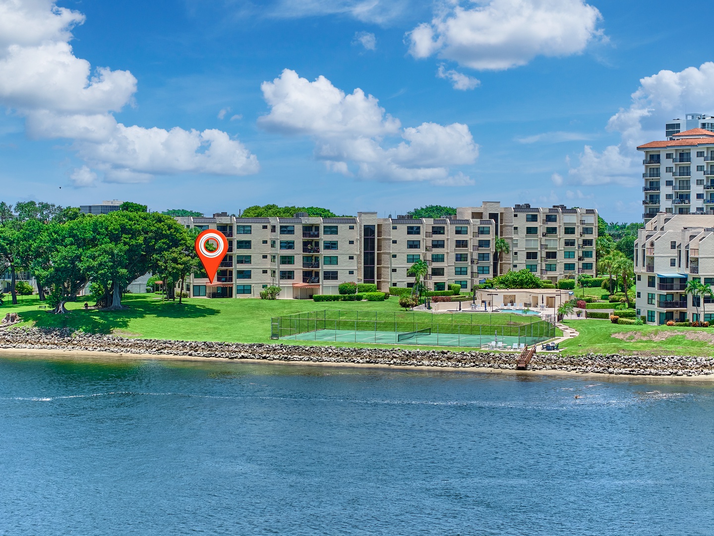 A picturesque waterfront property nestled along peaceful shores, surrounded by lush greenery and recreational courts. The expansive grounds offer a tranquil lakeside setting for your vacation retreat.
