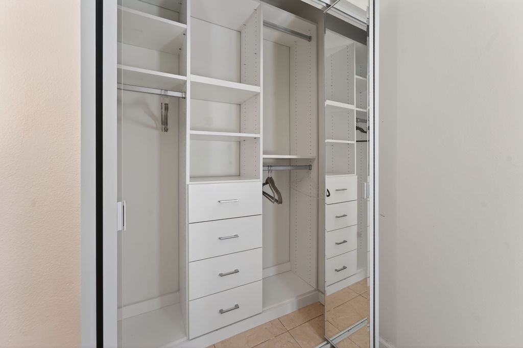 Step into your walk-in closet with custom shelving, drawers, and hanging space to organize all your belongings beautifully.