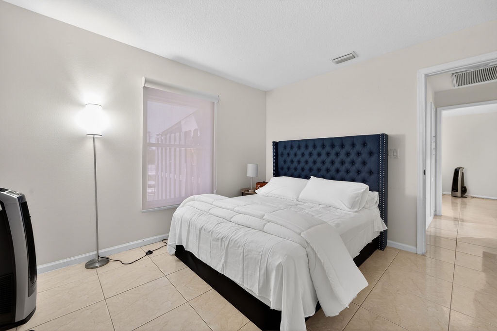 Sink into luxury with crisp white linens on your plush tufted bed, where soft lighting creates the perfect ambiance for restful nights.