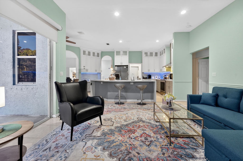 Relax in your stylish open-plan living space where calming mint walls frame a fully-equipped kitchen and comfortable seating area.