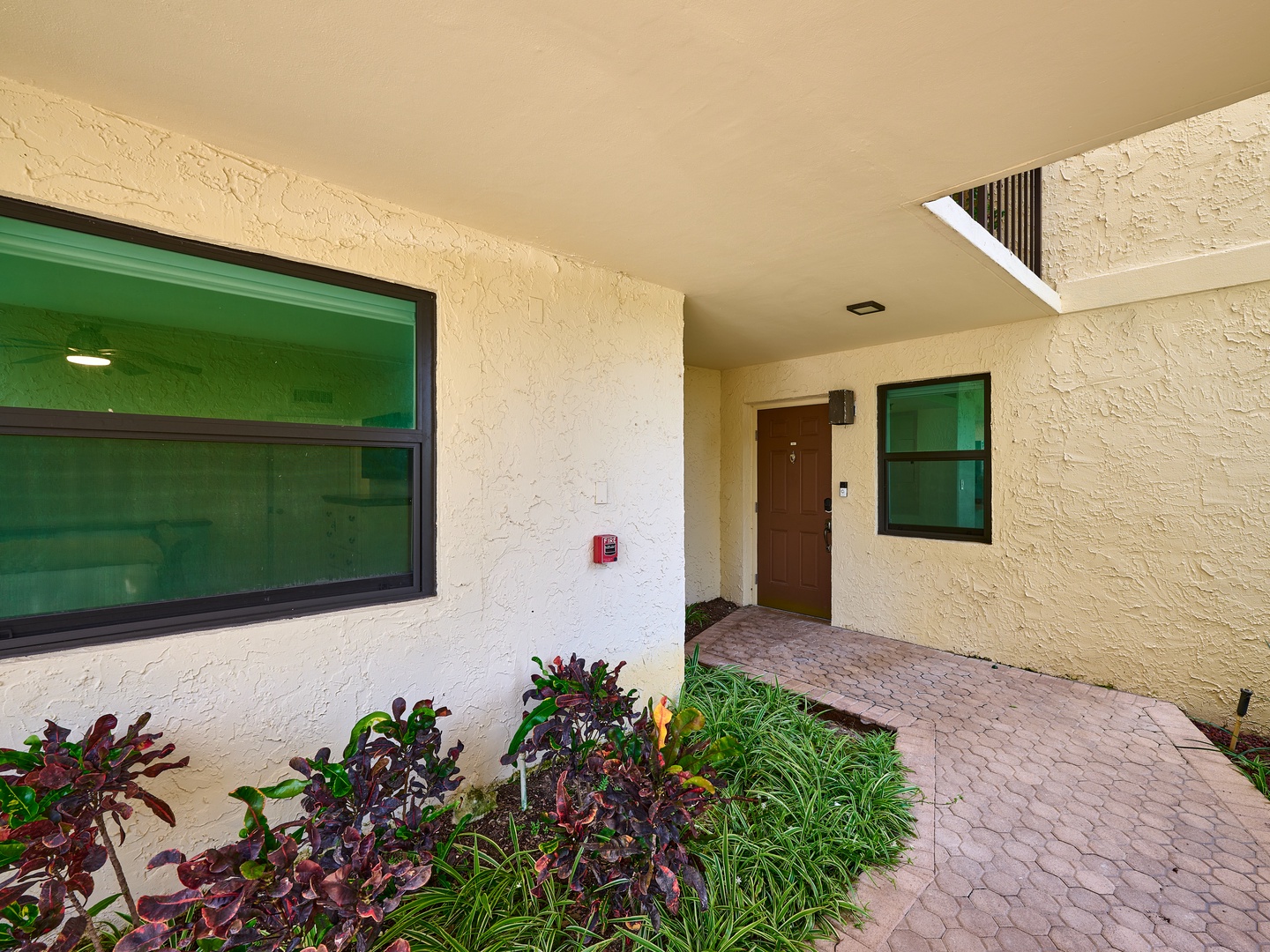 The entryway features a covered walkway with decorative landscaping and a private entrance, providing easy access to your vacation home.