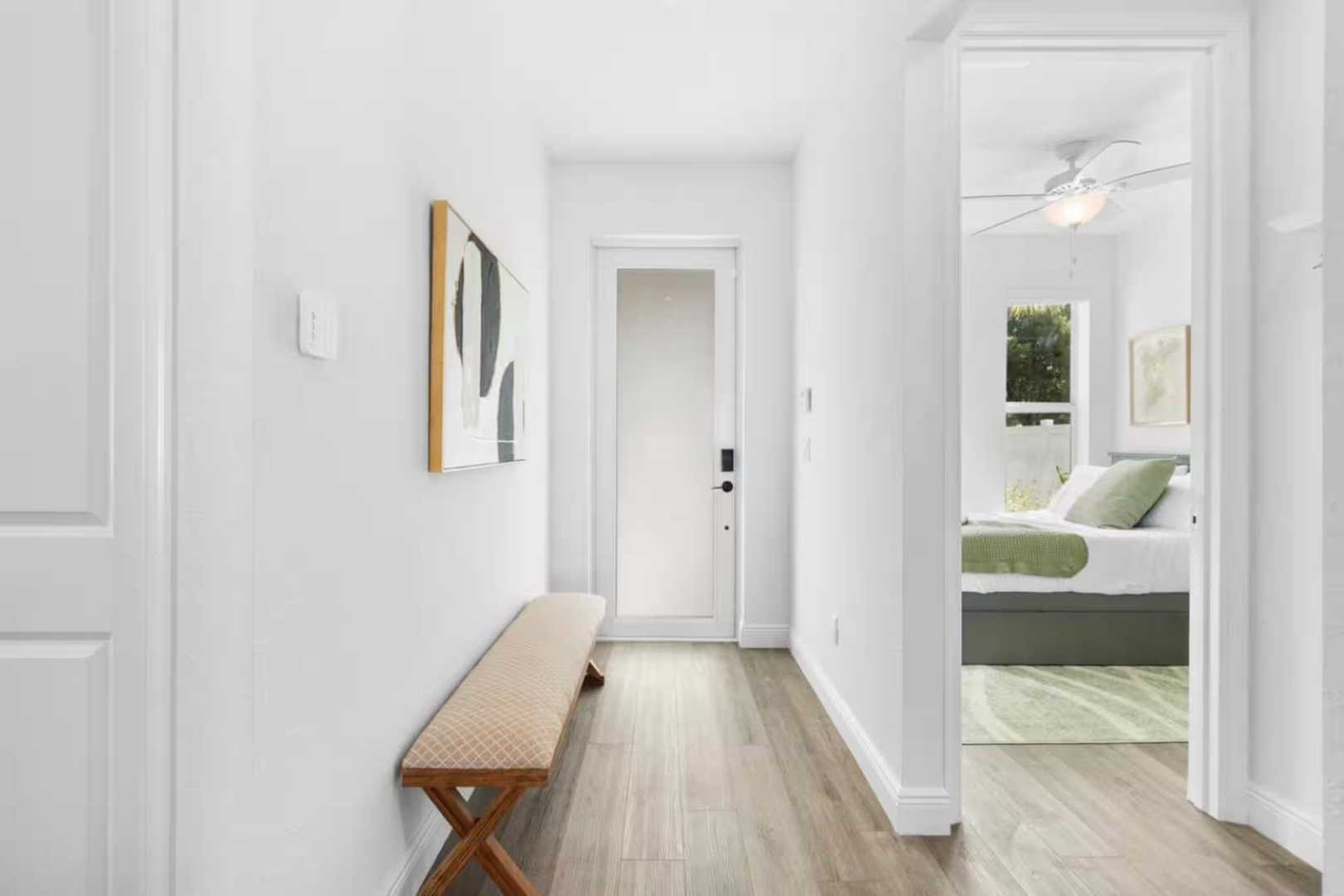 Step into this bright, serene hallway where crisp white walls and warm wood floors guide you toward restful spaces—your peaceful retreat awaits just beyond each door.