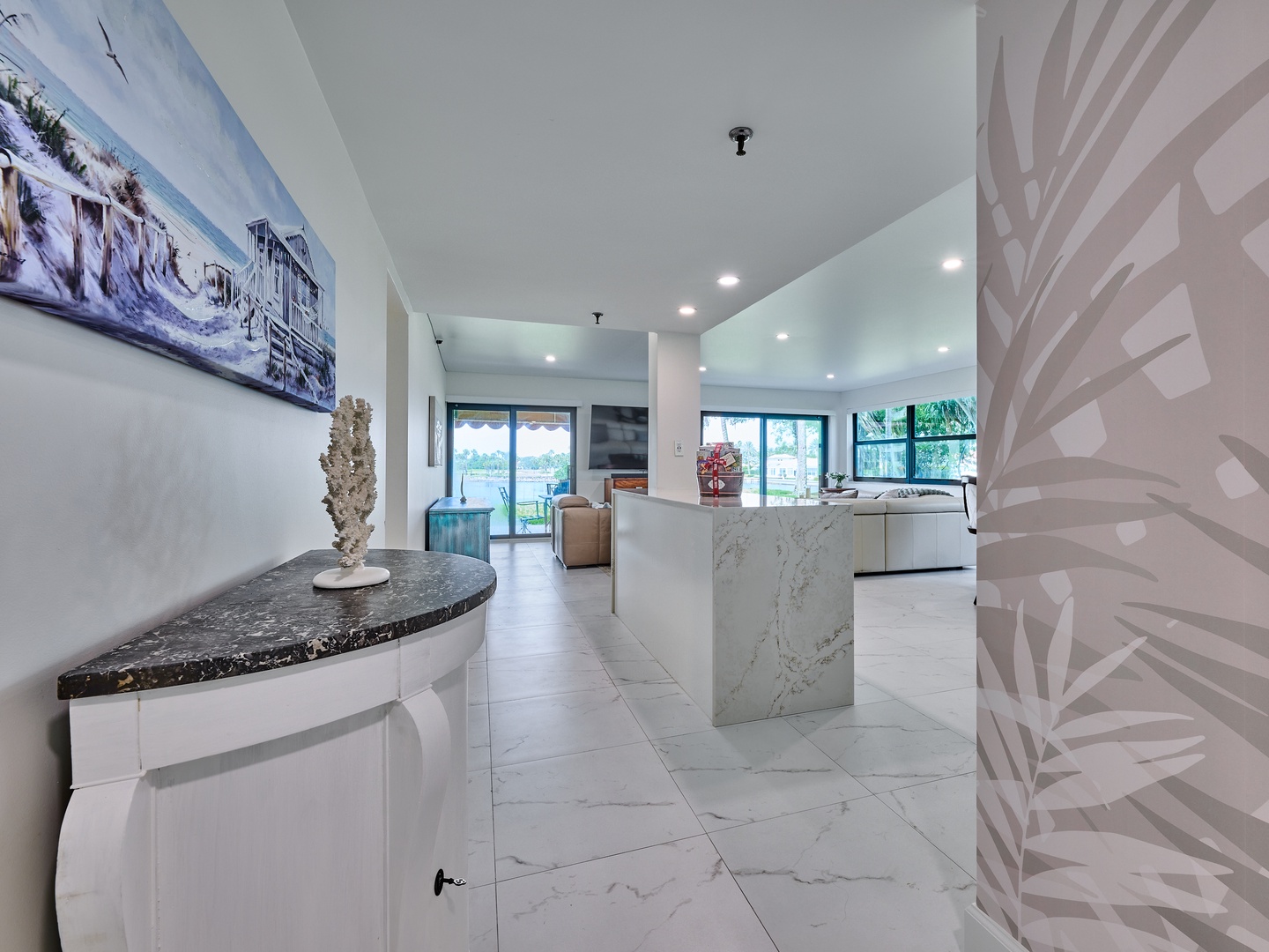 Step into your open-concept living space where sleek marble finishes and natural light create a bright, contemporary atmosphere. The seamless flow from kitchen to living room invites you to relax and unwind in style.