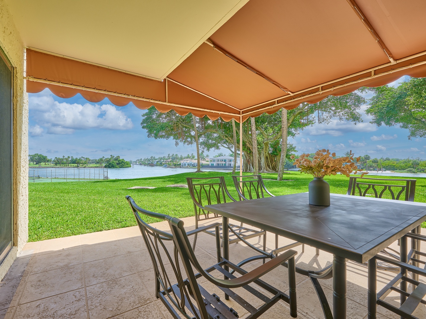Picture yourself dining alfresco under the shade of your private awning, where lush waterfront views and gentle breezes set the scene for peaceful moments in your own lakeside retreat.