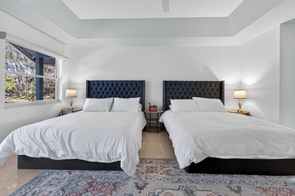 Sink into luxurious comfort with two plush beds featuring elegant tufted headboards and premium linens in your peaceful retreat.