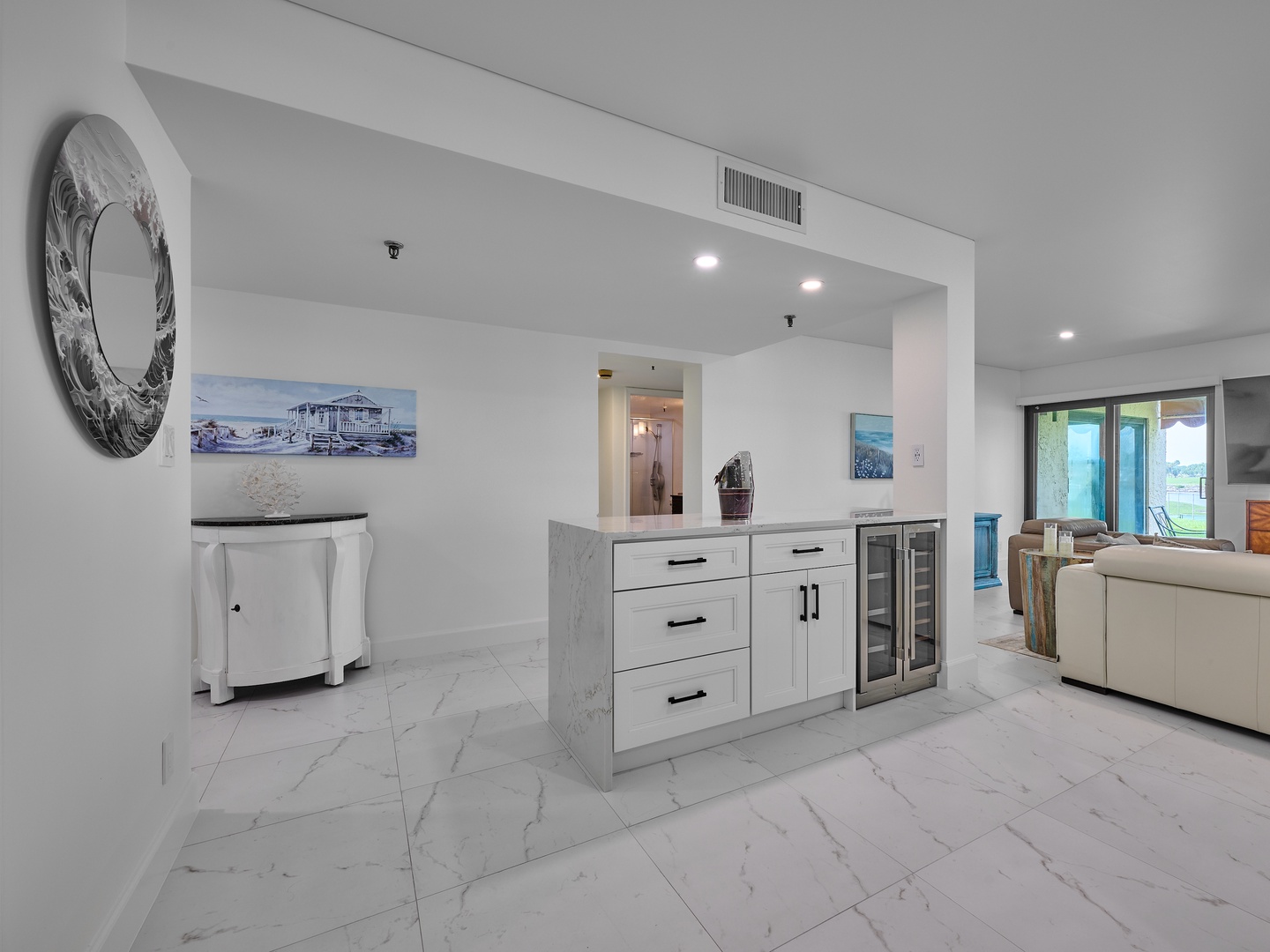 Bright, open space with elegant marble-look flooring and coastal-inspired art setting a relaxed, breezy tone for your stay.