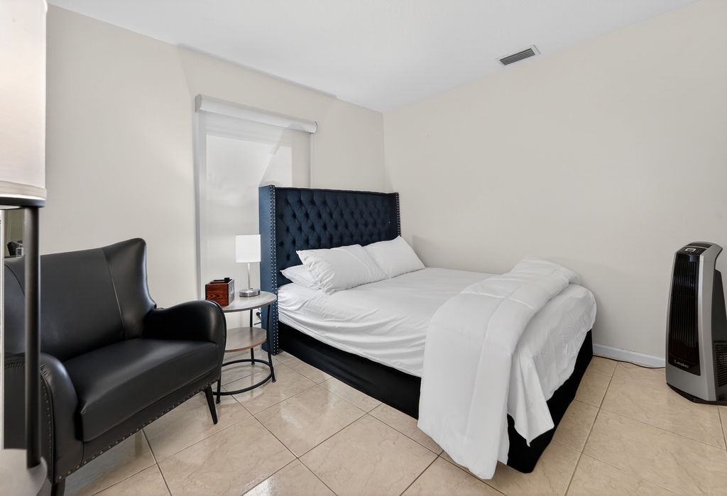 Drift into peaceful sleep in your elegant bedroom featuring crisp white linens, a plush tufted headboard, and modern comfort.