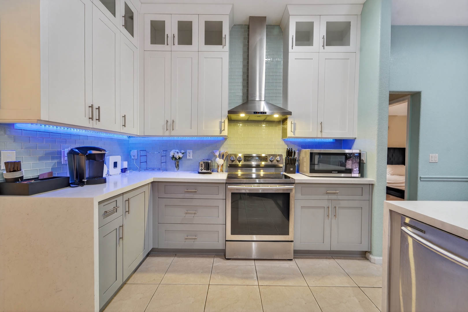 Your fully equipped kitchen features sleek white cabinets, stainless steel appliances, and atmospheric blue LED lighting for memorable meal prep.