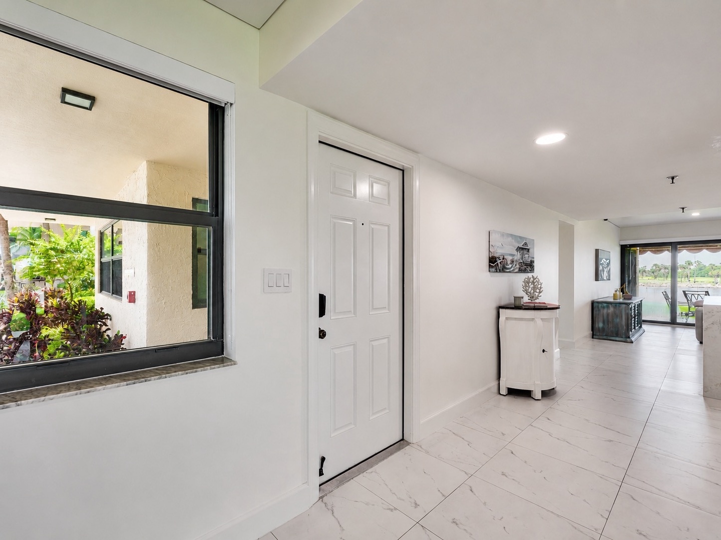 Step inside to discover bright, airy spaces with modern tile floors flowing throughout. Your peaceful retreat features tasteful decor and opens onto views of the lush tropical garden—welcoming you to a refreshing escape.