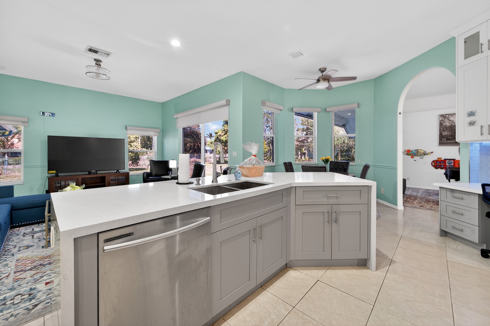 Your open-concept kitchen flows seamlessly into the living space, where soothing seafoam walls and abundant natural light create a calming retreat for cooking and gathering.