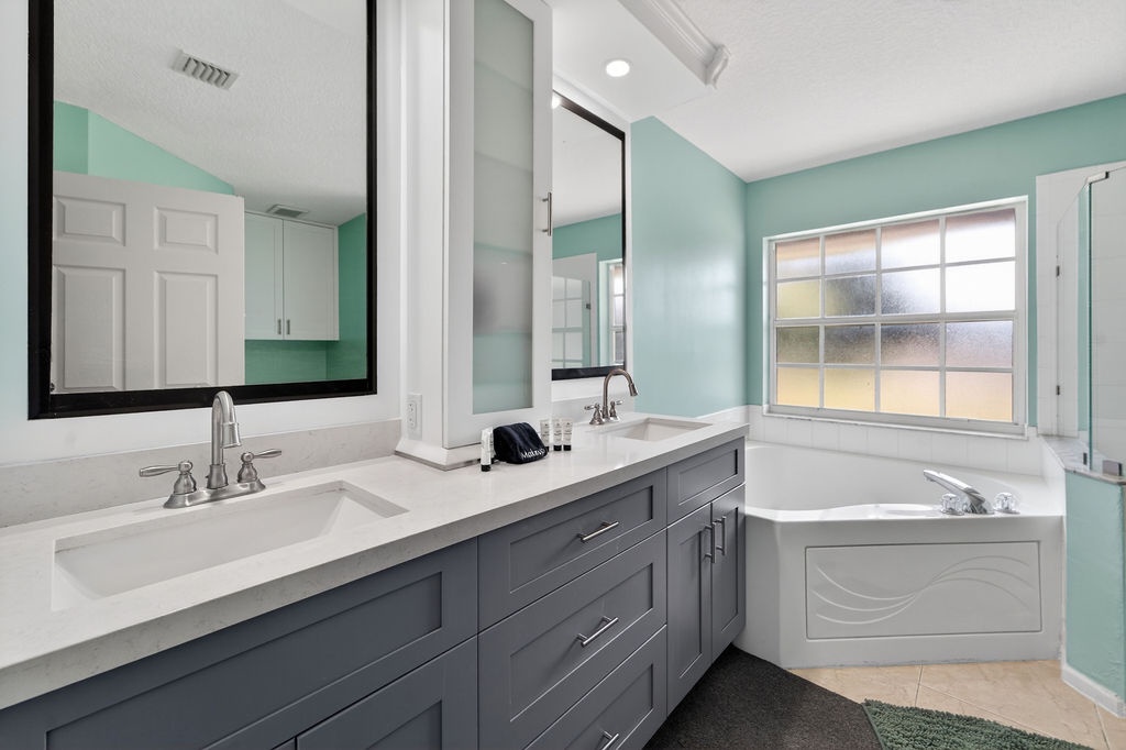 Step into your spa-like bathroom featuring dual vanities, a soaking tub, and soothing mint walls that create a peaceful retreat.