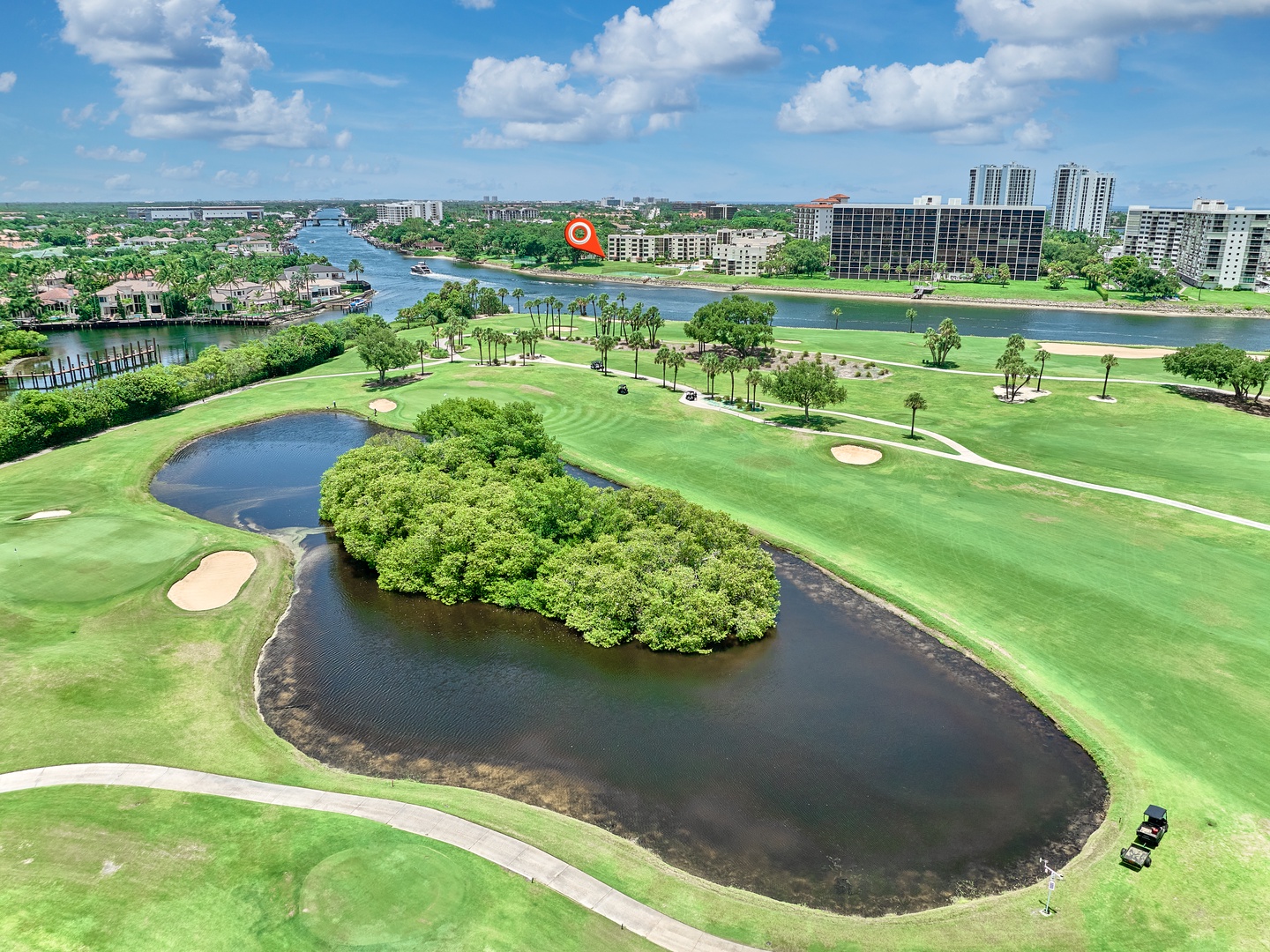 Aerial view capturing the property's setting along a scenic waterway, with a championship golf course and resort community neighboring the area.