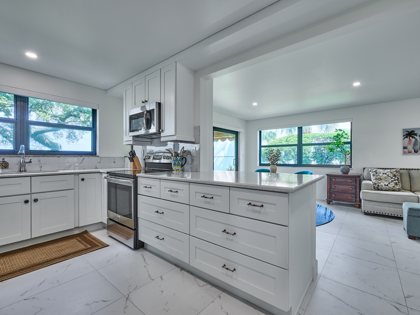 Step into your bright, fully-equipped kitchen where crisp white cabinetry and gleaming countertops invite you to whip up a meal. Soft natural light pours through large windows, creating a welcoming space to gather and unwind.