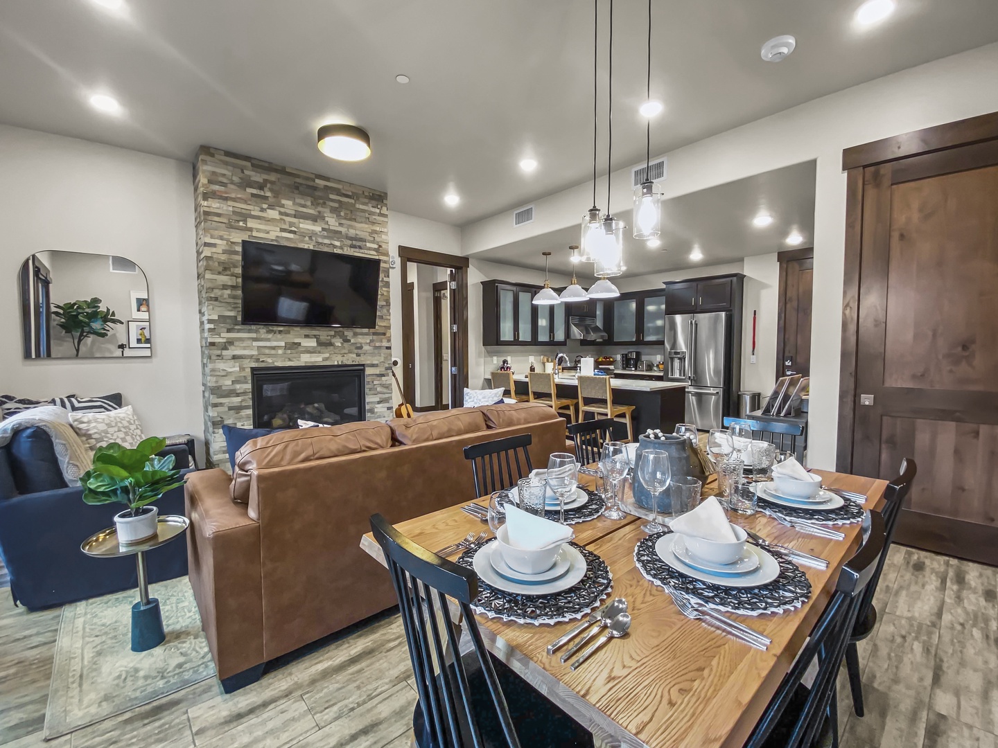 Step into your cozy retreat where a stylish dining table awaits gatherings, while the inviting living area with a fireplace beckons relaxation after your mountain adventures.