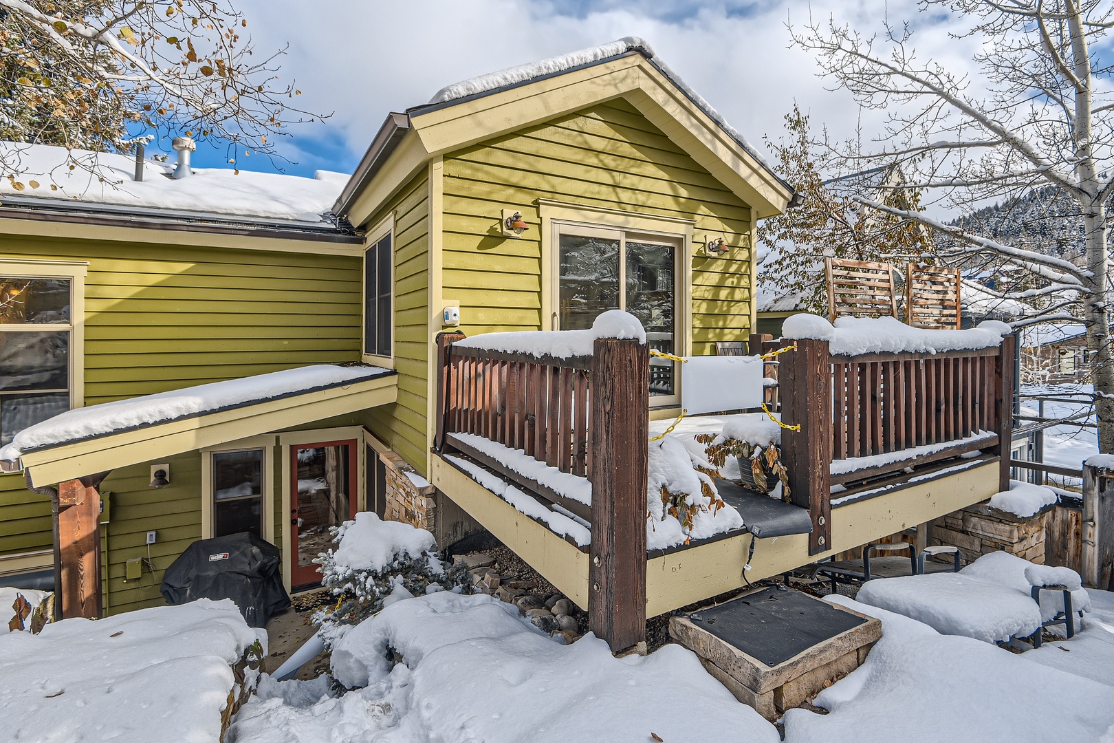 A charming mountain retreat nestled in a peaceful winter setting, this property offers direct access to snowy landscapes and features inviting outdoor spaces with scenic surroundings (backyard)