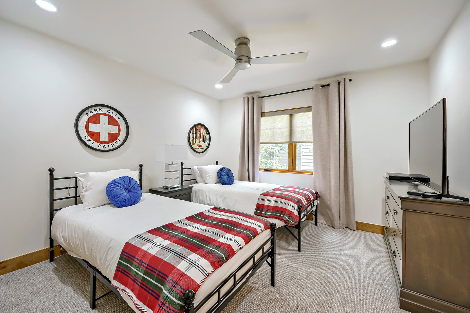 Crisp white linens, playful vintage accents, and two cozy beds make this bright room perfect for kids or friends traveling together. Natural light and a ceiling fan keep your space comfortable.