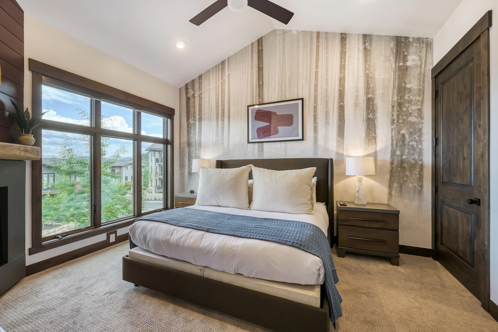 Unwind in this serene bedroom with a plush bed, calming accent wall, and views of greenery that help you recharge after your adventures.