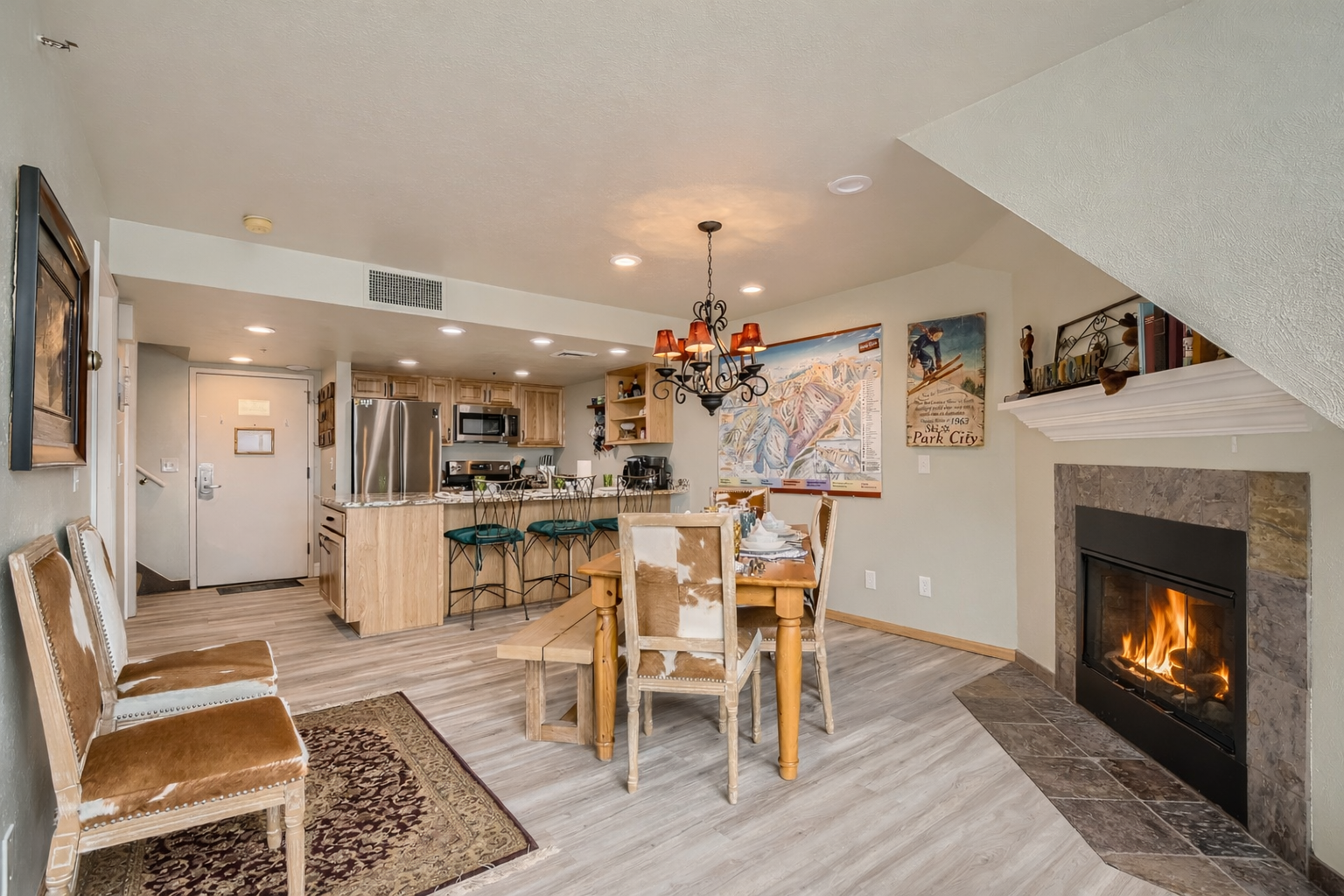 Open-concept living with kitchen, dining area, and stone fireplace. Your cozy mountain retreat awaits.