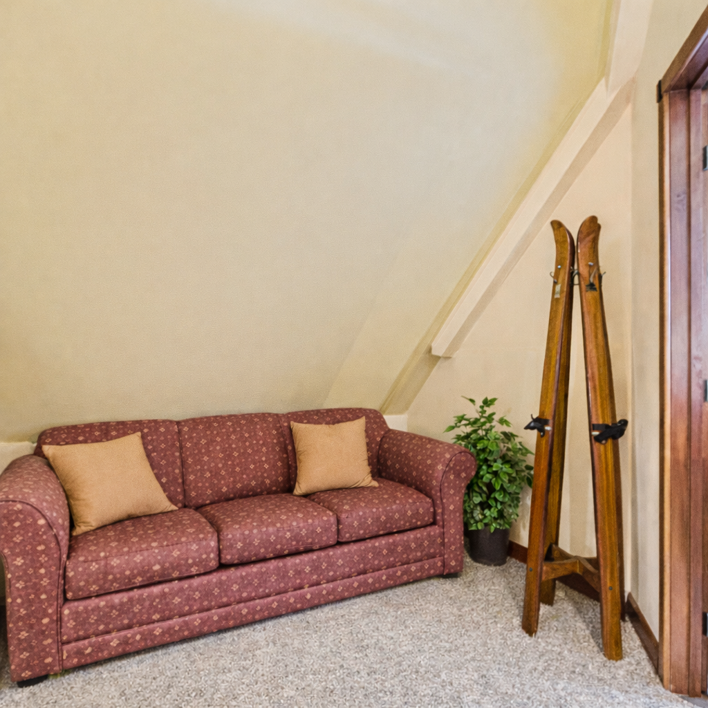 Charming seating nook with a comfortable sofa, warm lighting, and rustic ski décor. Perfect for reading, relaxing, or extra guest space during your Park City stay.