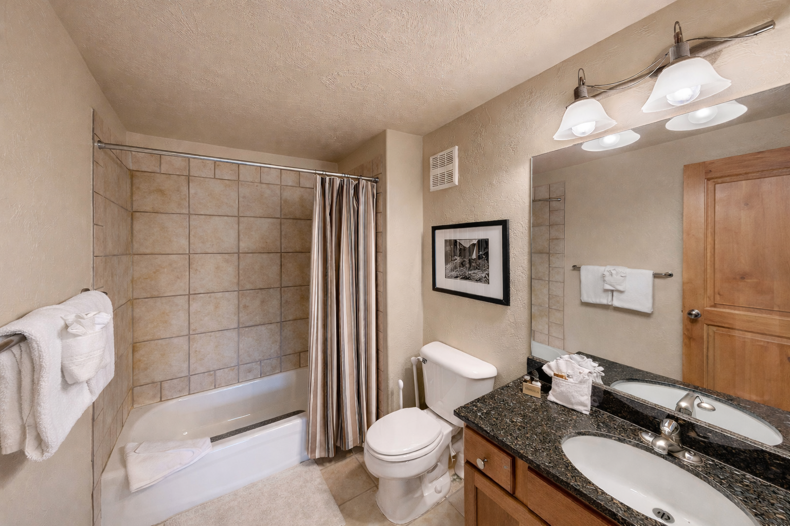Cozy full bathroom with a granite vanity, ample counter space, and a combination tub/shower for a relaxing soak after your day exploring