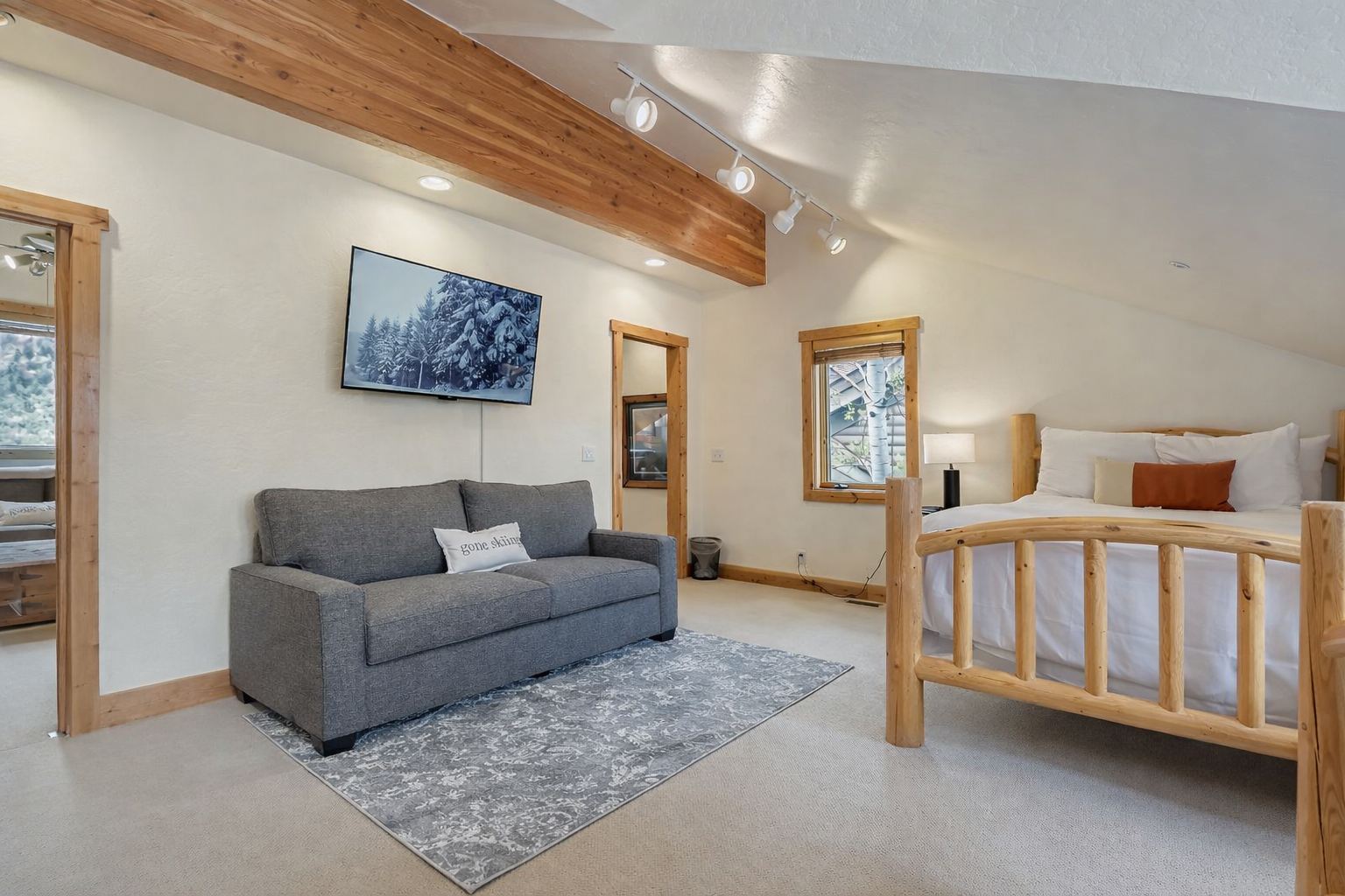 Relax in your charming loft with exposed beams, cozy seating area, and mountain views on the wall-mounted TV.