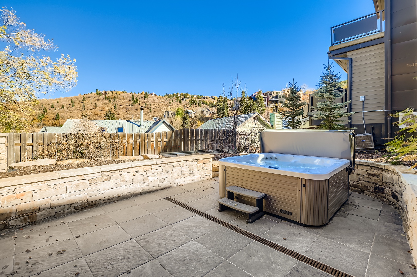 Soak in the private hot tub while taking in mountain views from this spacious patio, perfect for unwinding after a day of adventure.