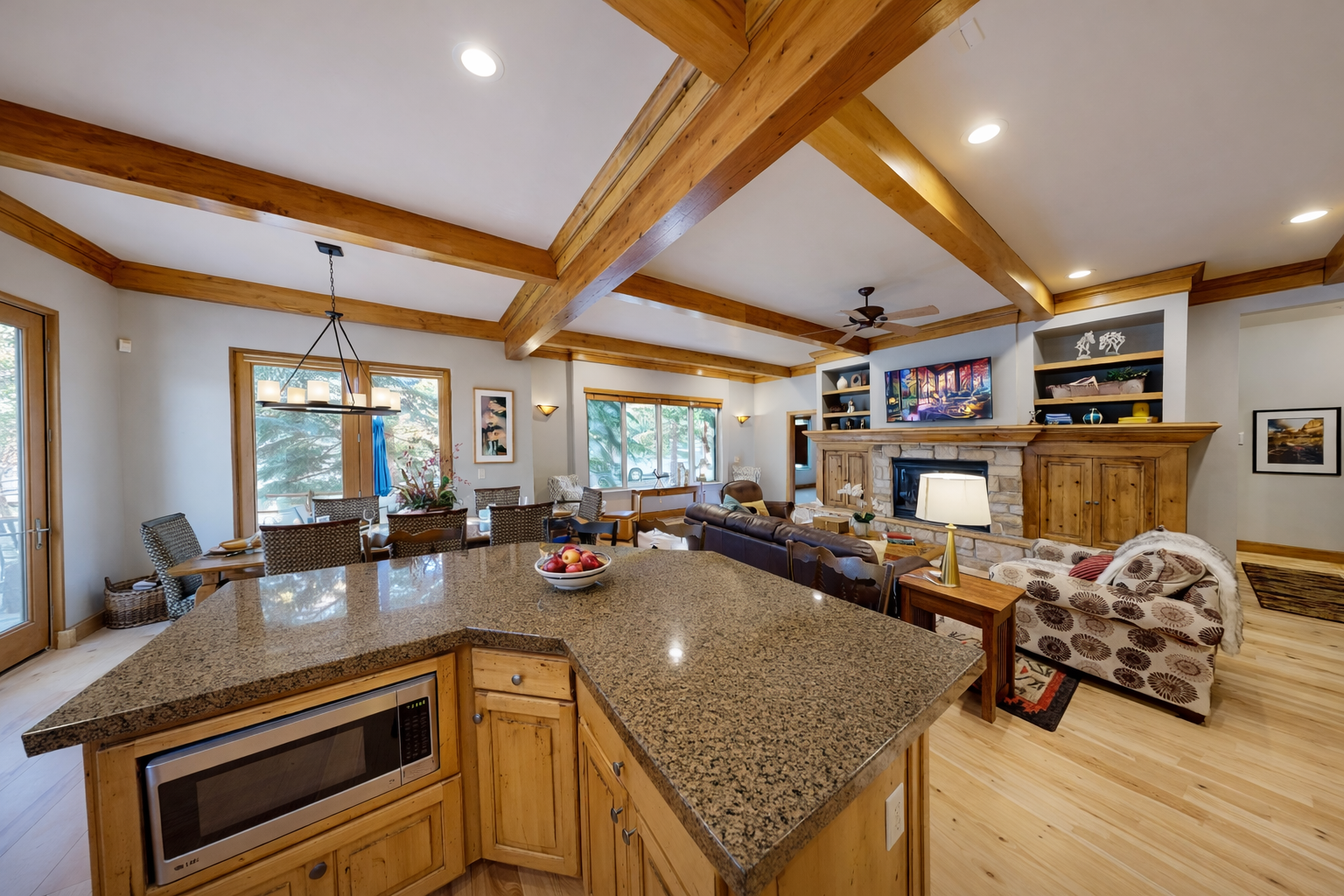 You'll love this open-concept space where rustic wood beams meet granite countertops, creating the perfect gathering spot for meals and relaxation.