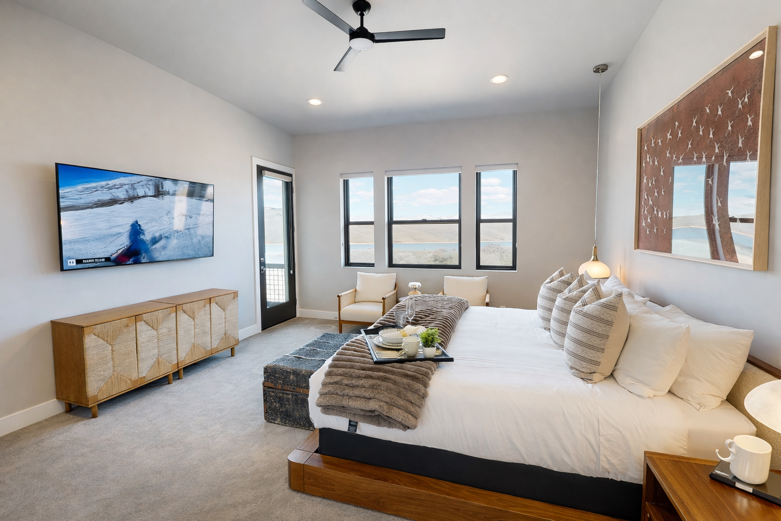 Relax in this bright, modern bedroom featuring a plush king bed, stylish decor, and cozy seating. Large windows offer stunning views, creating the perfect serene escape for your stay.